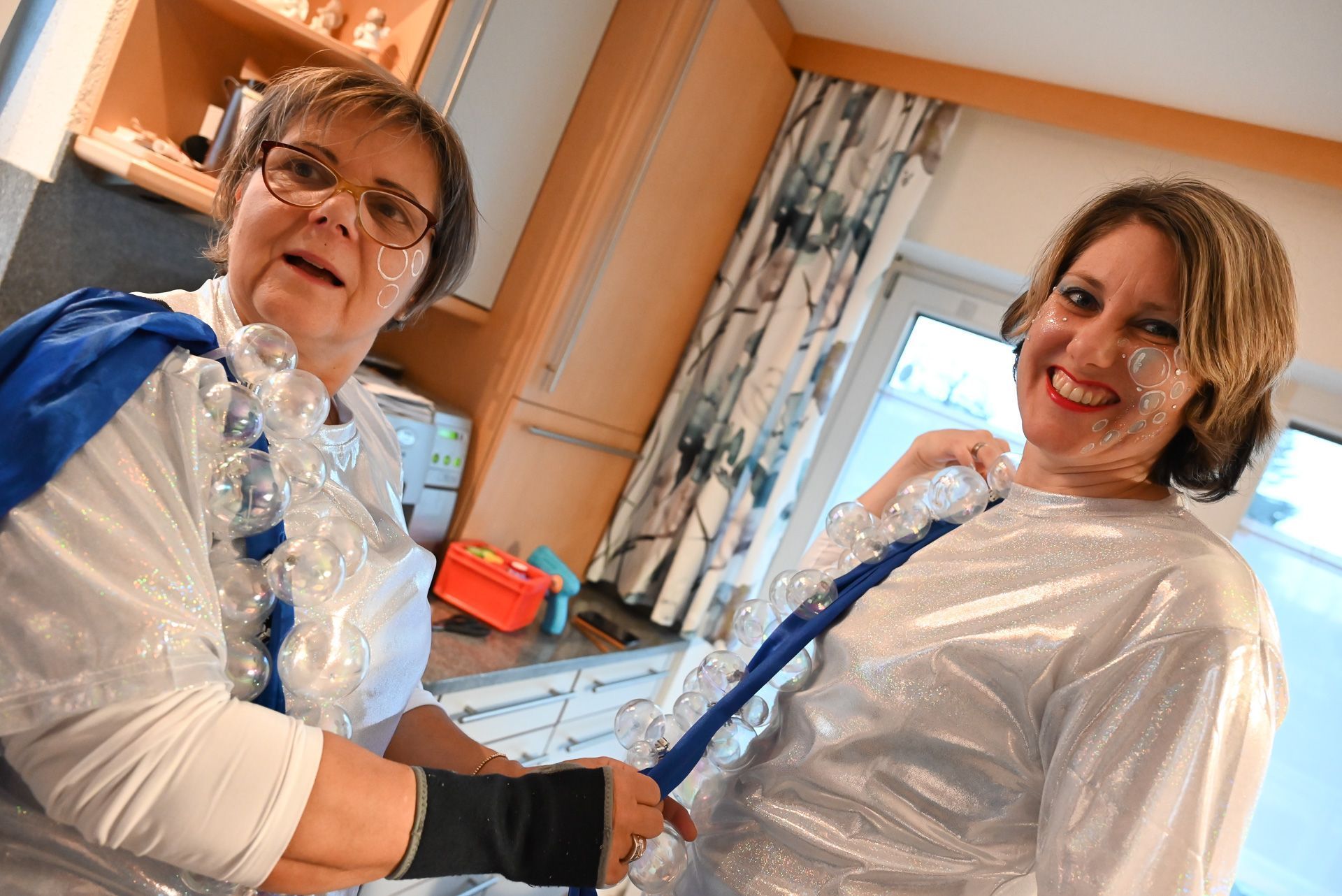 Gabi hilft Tamara bei den letzten Vorkehrungen an der Seifenblasenschleppe.