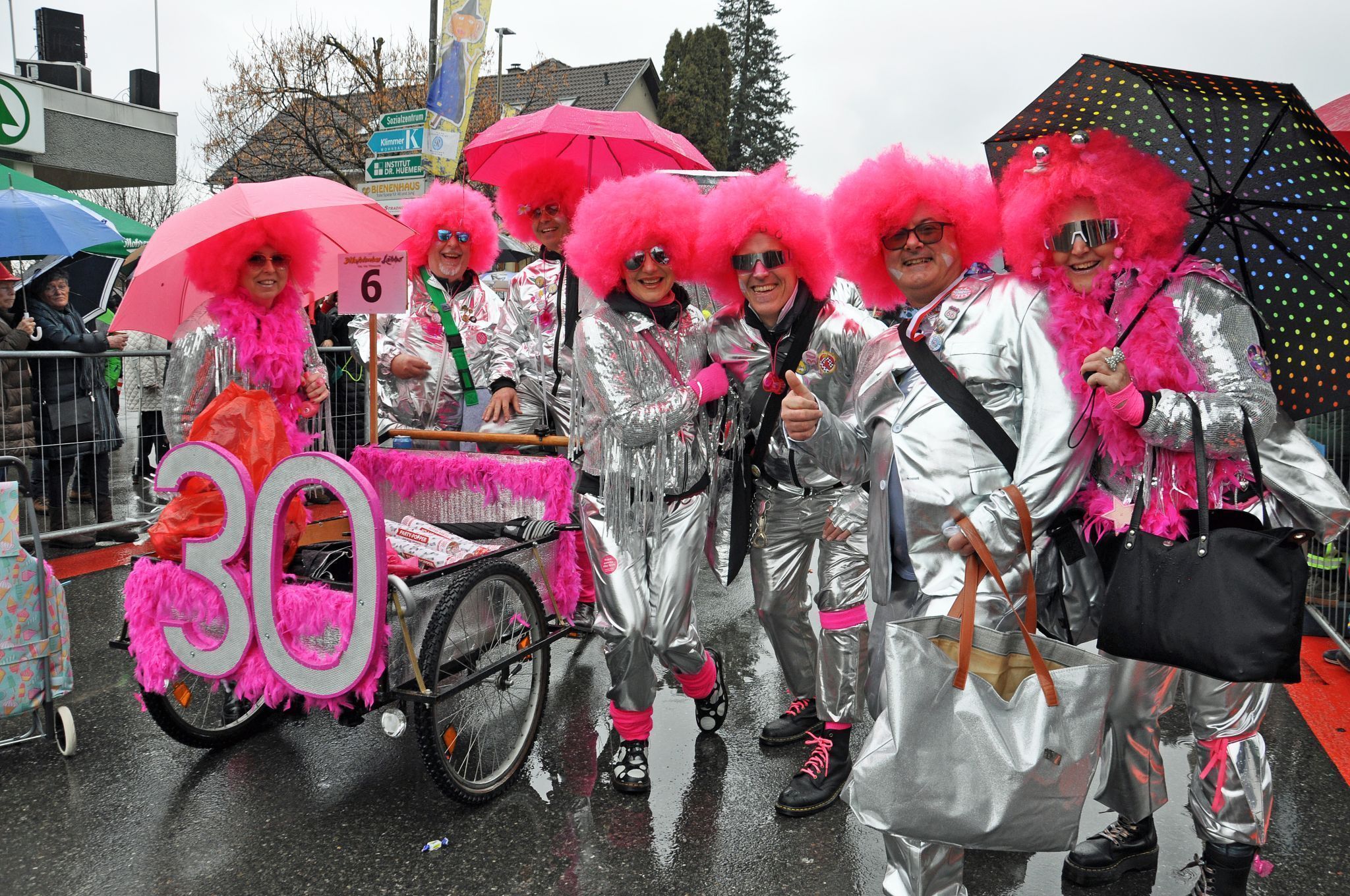Die Faschingsgruppen trotzen dem Regen beim Umzug mit bunten Kostümen.