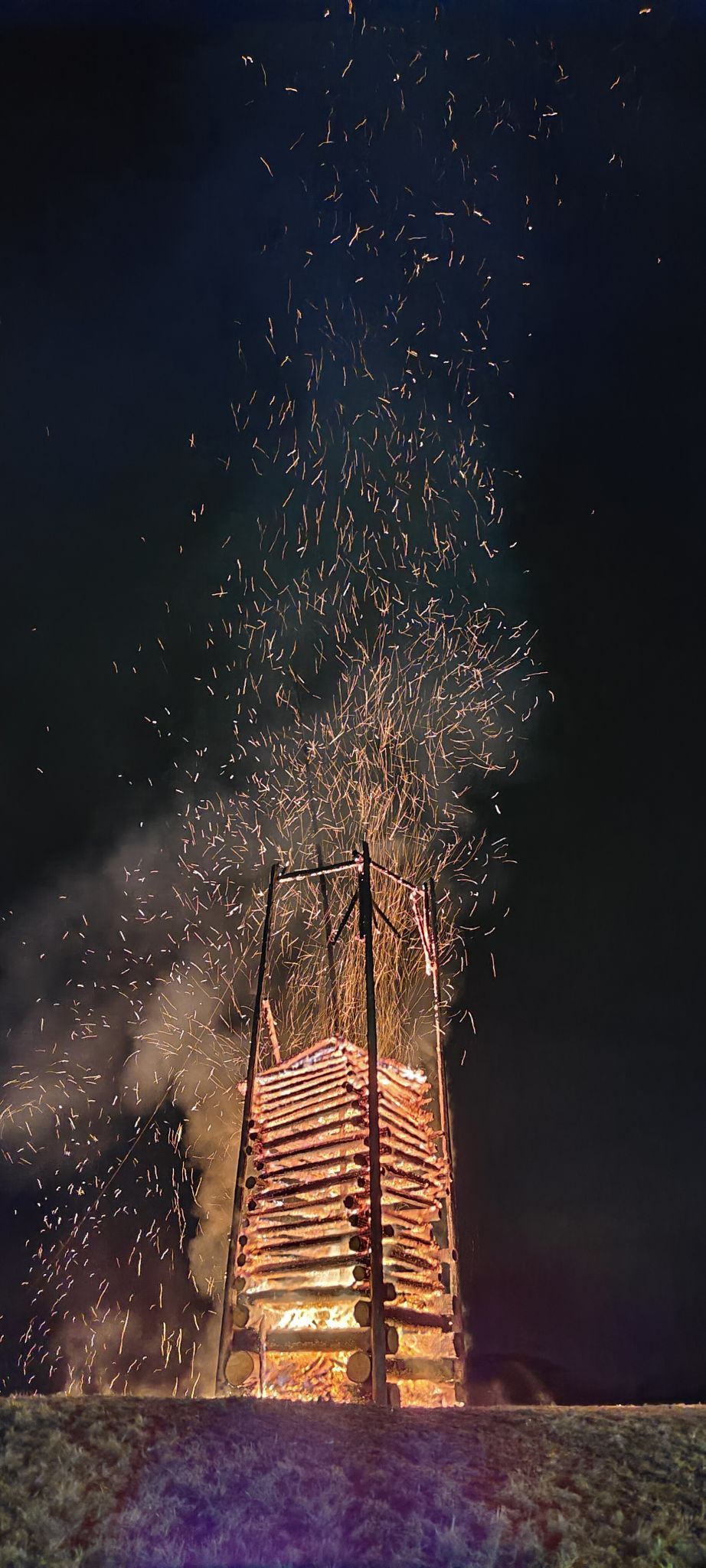 Der Funkenflug erleuchtete den Abendhimmel in warmen Licht.