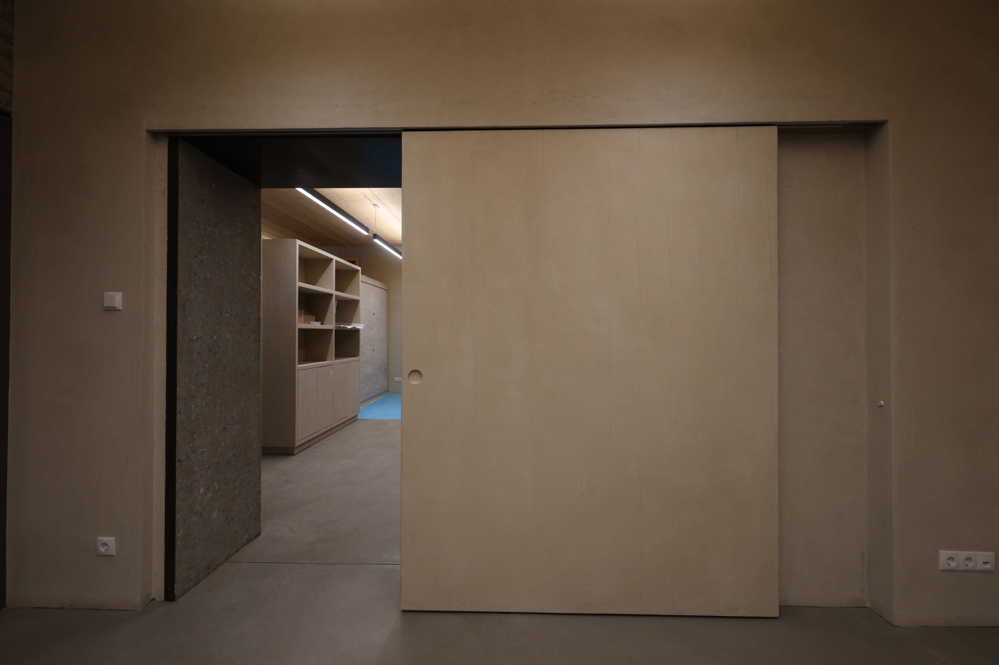 Die Schiebetür ist ein mit Lehm beschichtetes Holzelement.