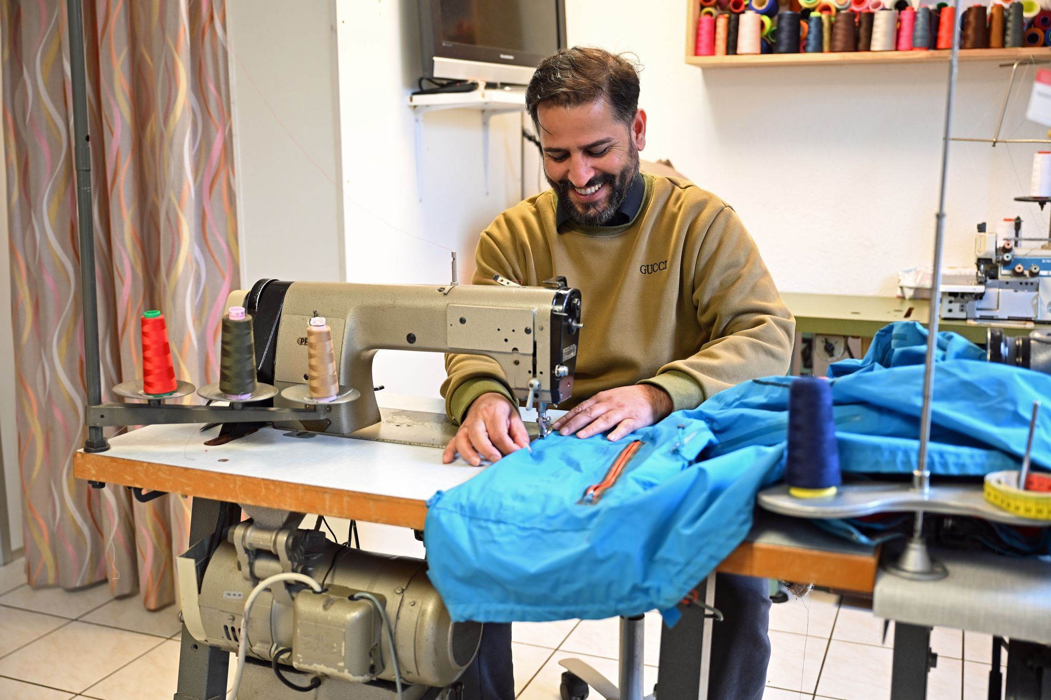 •	Zia Malikzai an einer seiner vier Nähmaschinen in seiner Änderungsschneiderei in Wolfurt.