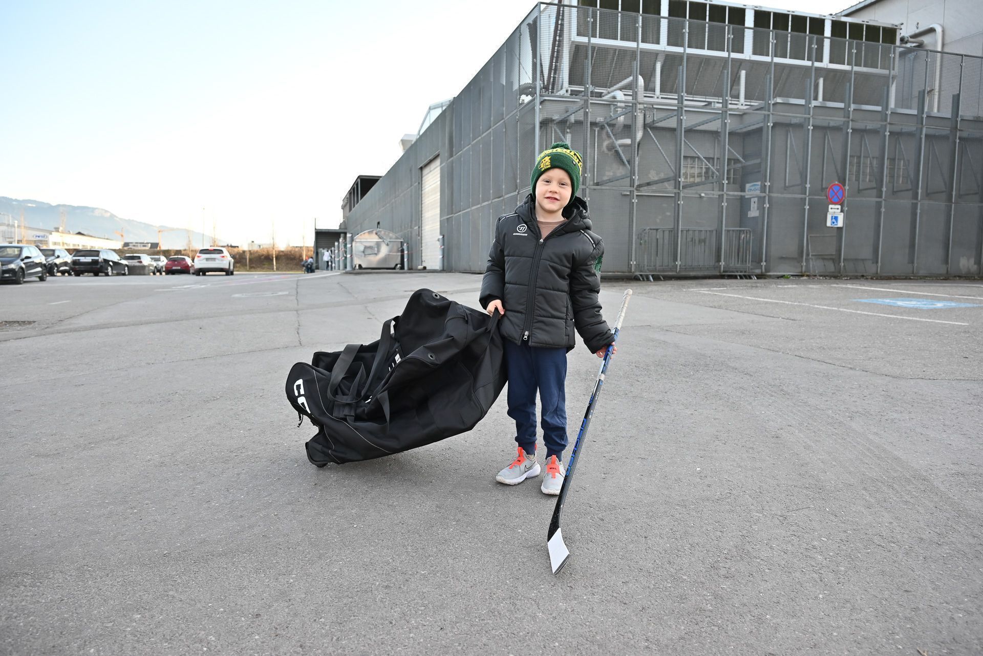 Die Tasche ist fast so groß, wie der junge Eishockeyspieler. Alleine kann er nicht anreisen und sich auch nicht anziehen, zu komplex ist dies zu Beginn für die Kinder. 