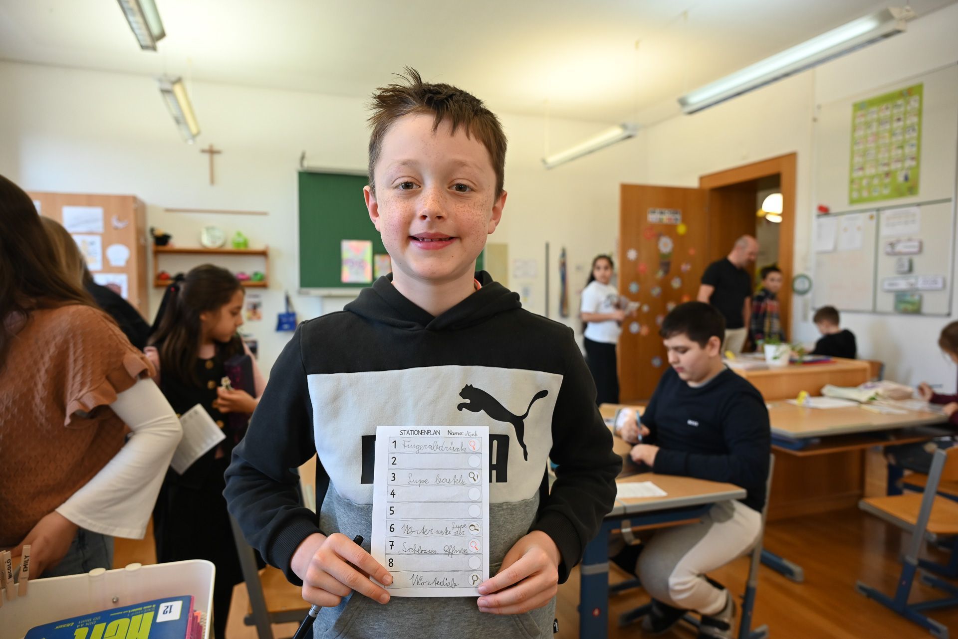 Noah zeigt stolz seinen Stationenpass.