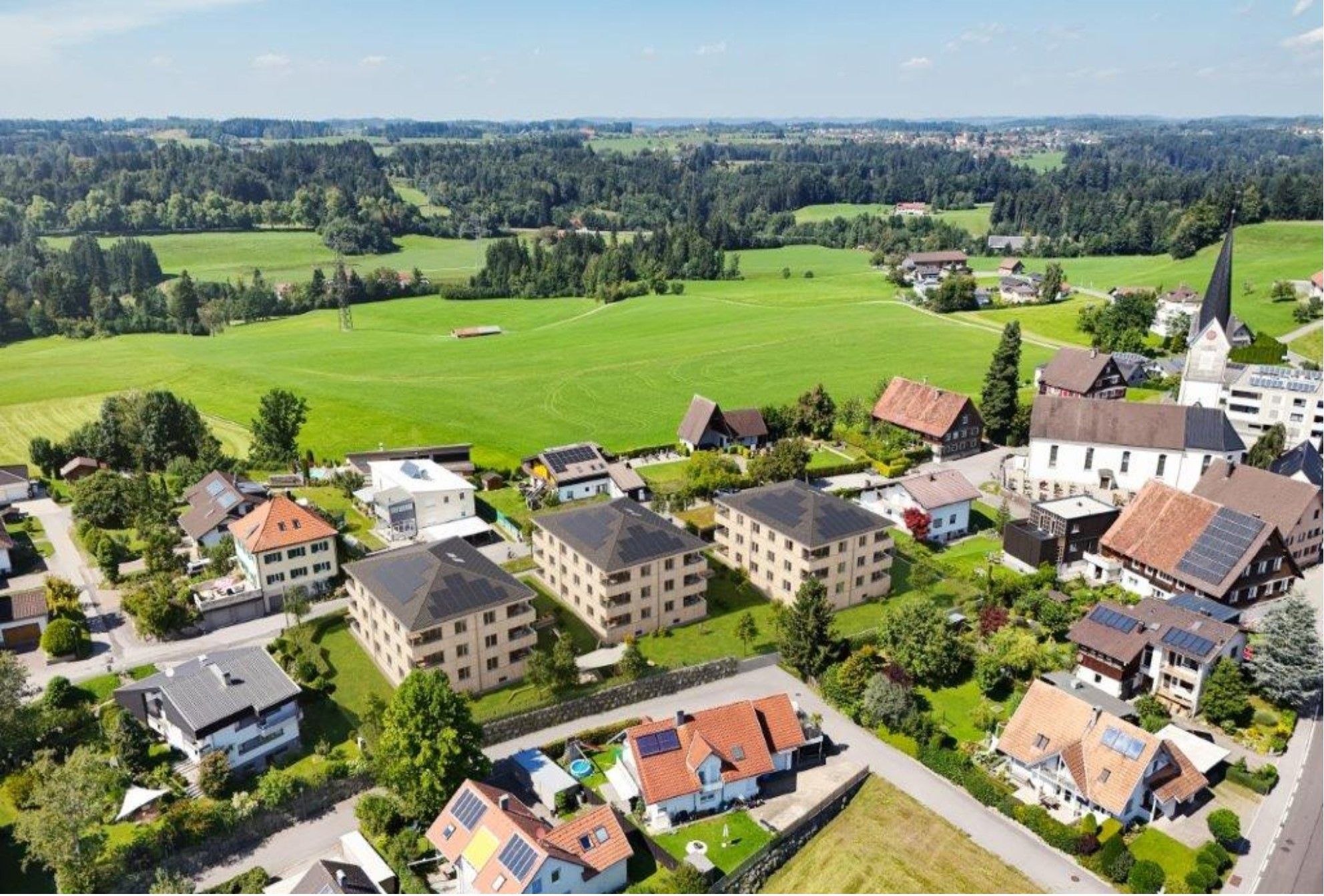 Drei Baukörper mit insgesamt 30 Wohnungen wurden von Planerin Susanne Gaudl behutsam in ihr Umfeld eingefügt. Mit Holzfassaden und  Walmdächern passen sich die Objekte den „Nachbarn“ an.   