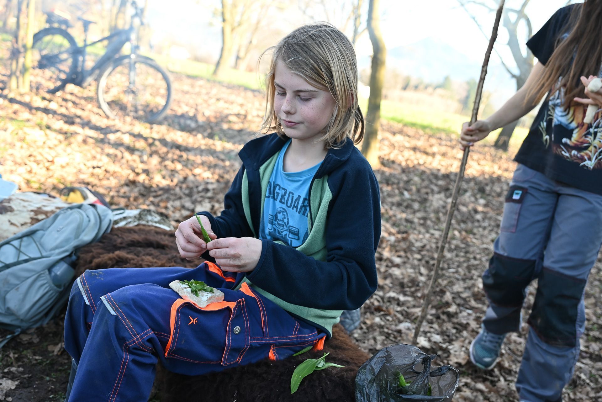Jeppe gibt noch etwas Bärlauch zum Stockbrotteig hinzu.