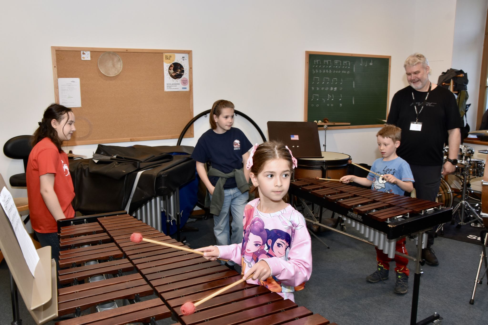 Veronika Huber mit Tochter Amrei am Xylophon. Musikschullehrer Ulli Sparr am Schlagzeug und mit Schülern/Besuchern. Schule im Park in Bludenz. (Bildergalerie)
