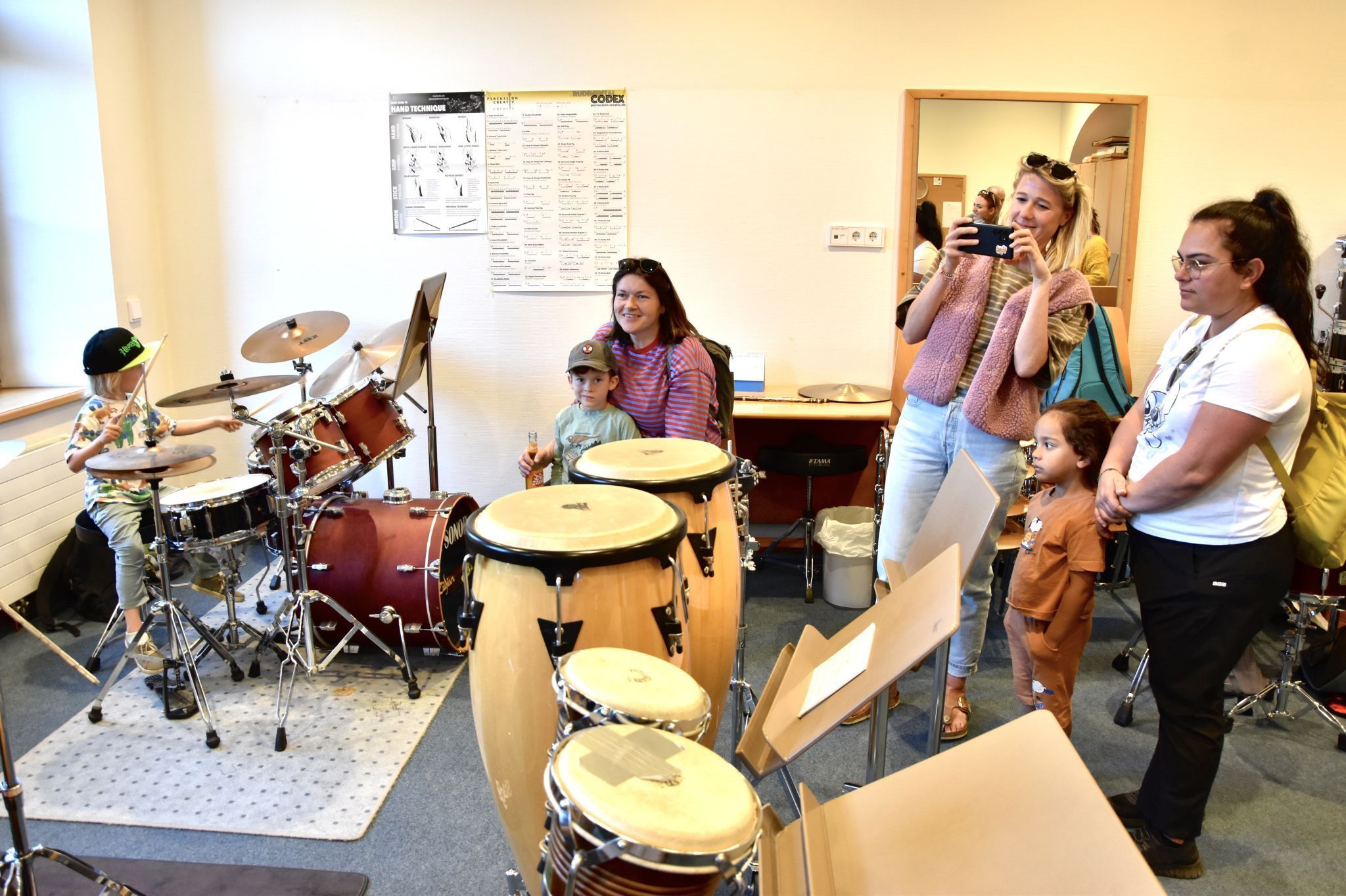 Veronika Huber mit Tochter Amrei am Xylophon. Musikschullehrer Ulli Sparr am Schlagzeug und mit Schülern/Besuchern. Schule im Park in Bludenz. (Bildergalerie)
