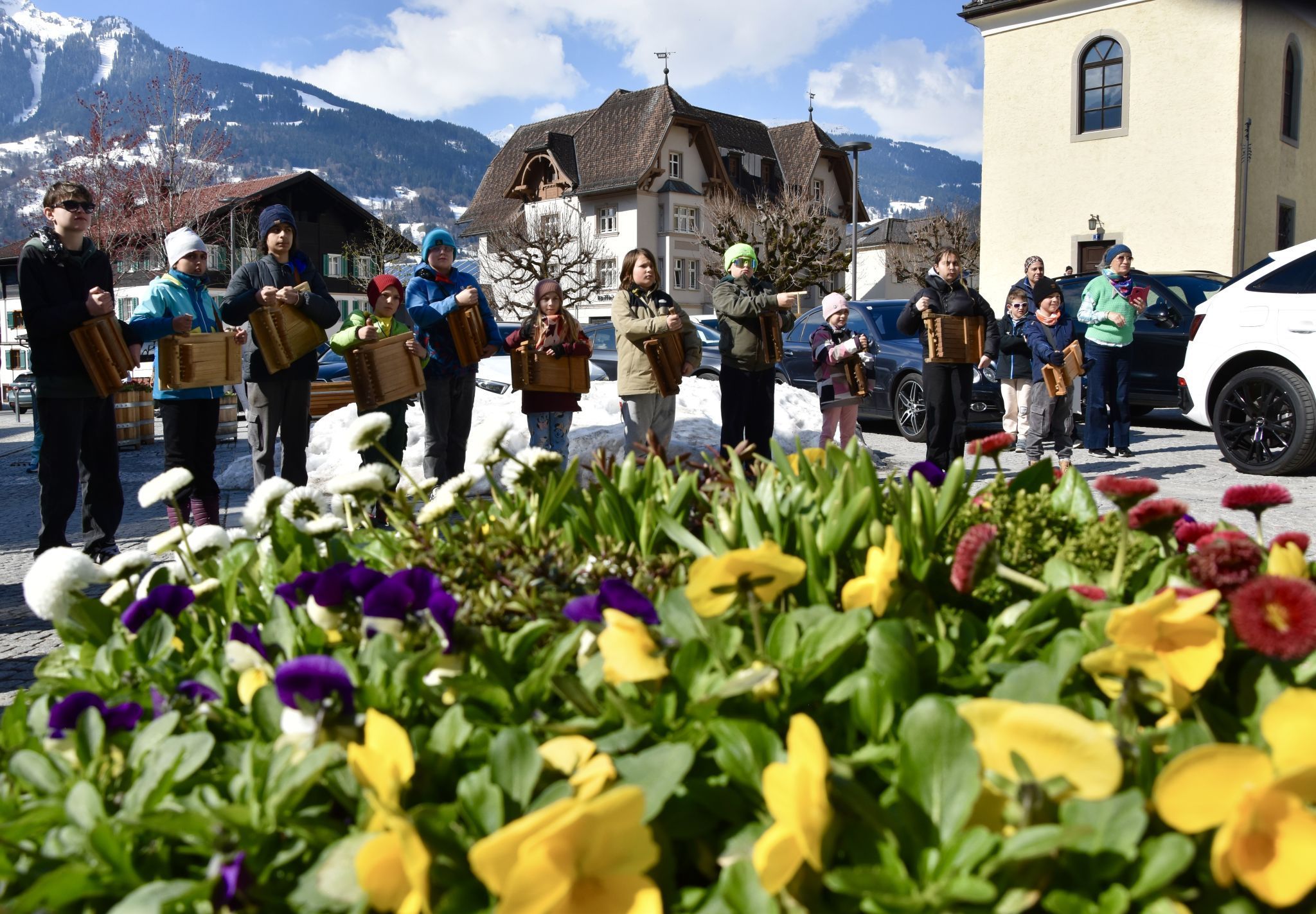 Die Schrunser Rätschnerinnen und Rätschner am Schrunser Kirchplatz, im Hintergrund die Tschaggunser Mittagsspitze