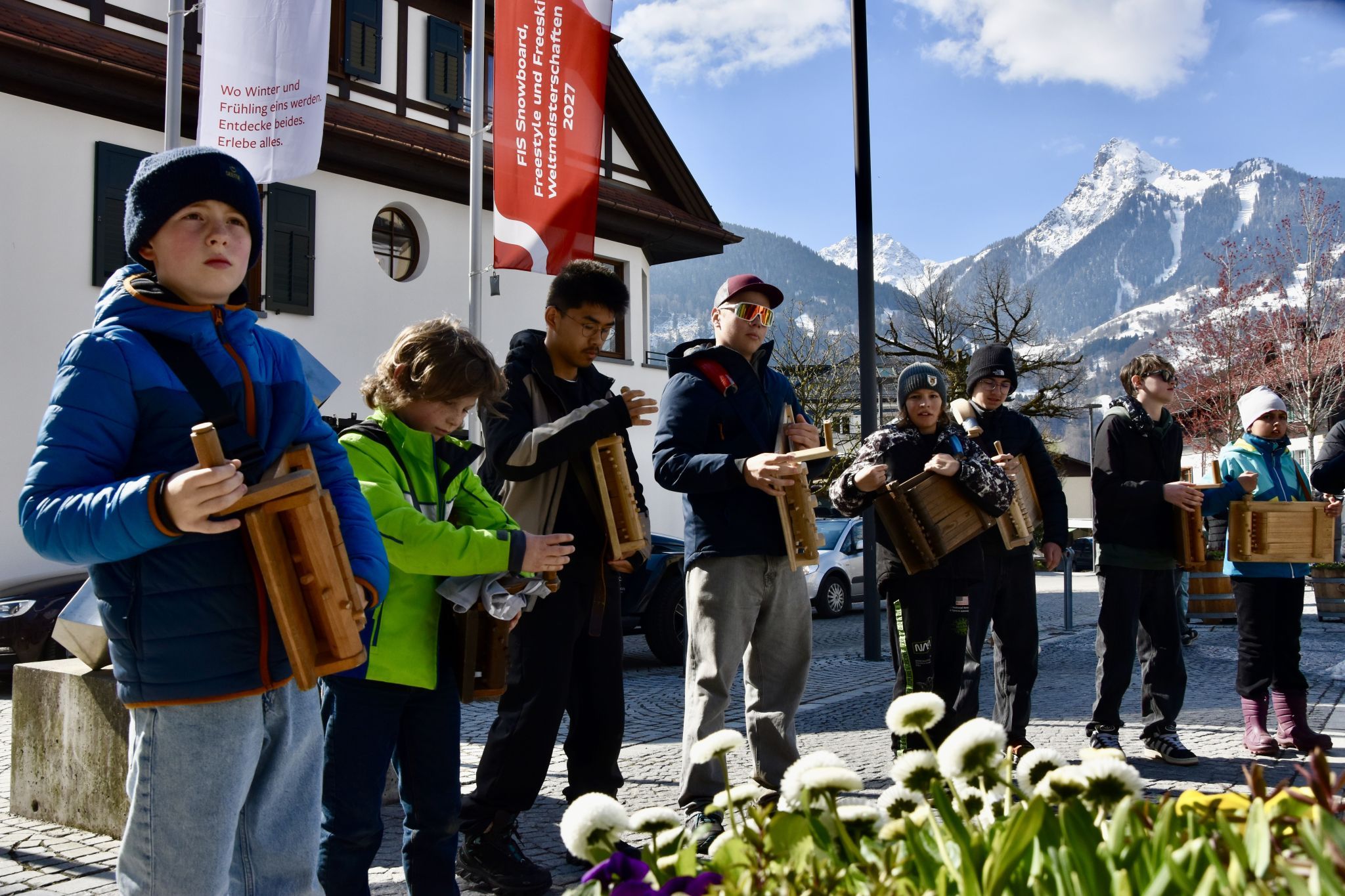 Die Schrunser Rätschnerinnen und Rätschner am Schrunser Kirchplatz, im Hintergrund die Tschaggunser Mittagsspitze