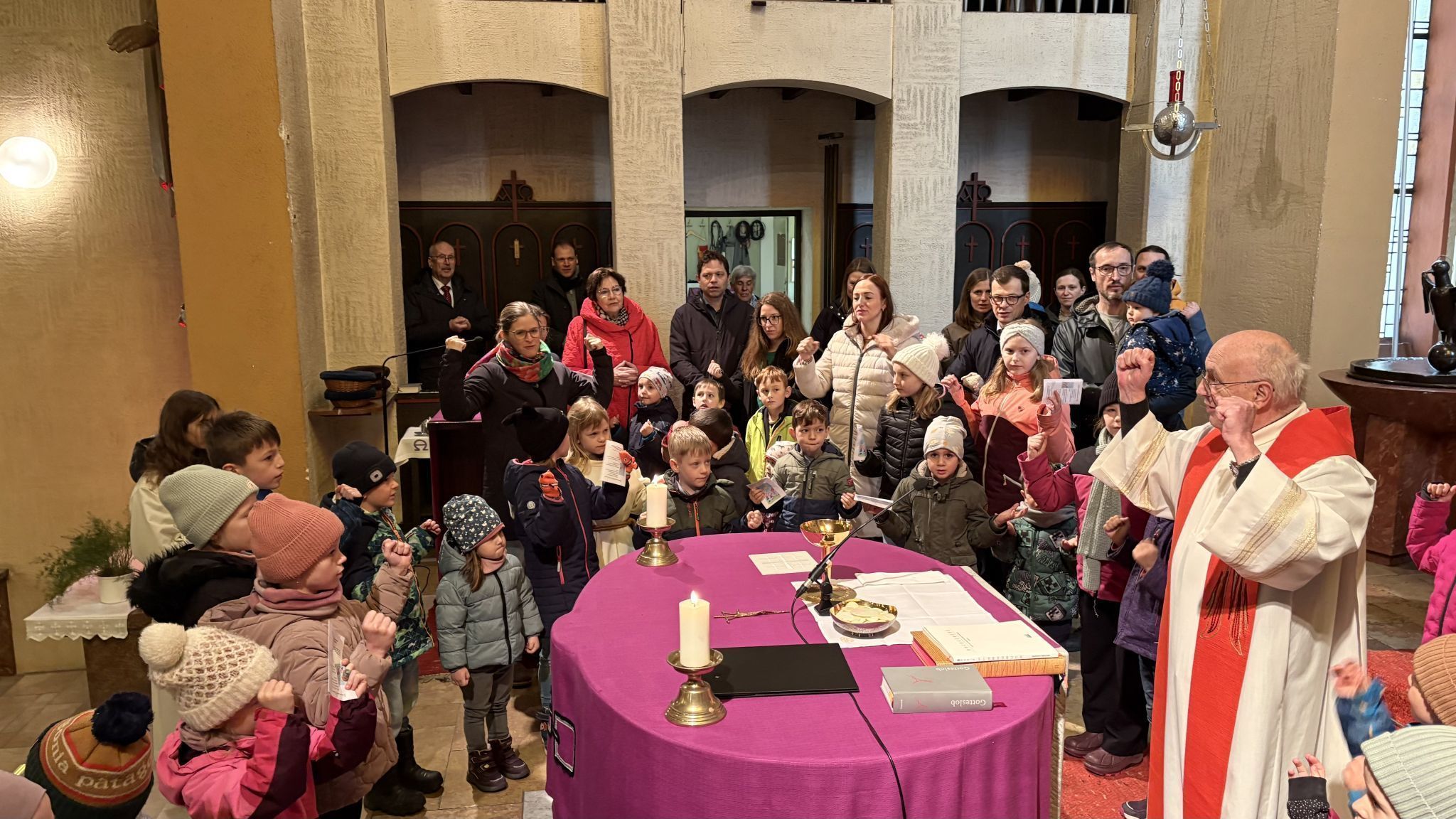 Nach der Rückkehr aus der Unterkirche der Pfarrkirche Heilig Kreuz versammelten sich die Kinder am Palmsonntag mit Pfarrer Roland Trentinaglia um den Altar der 