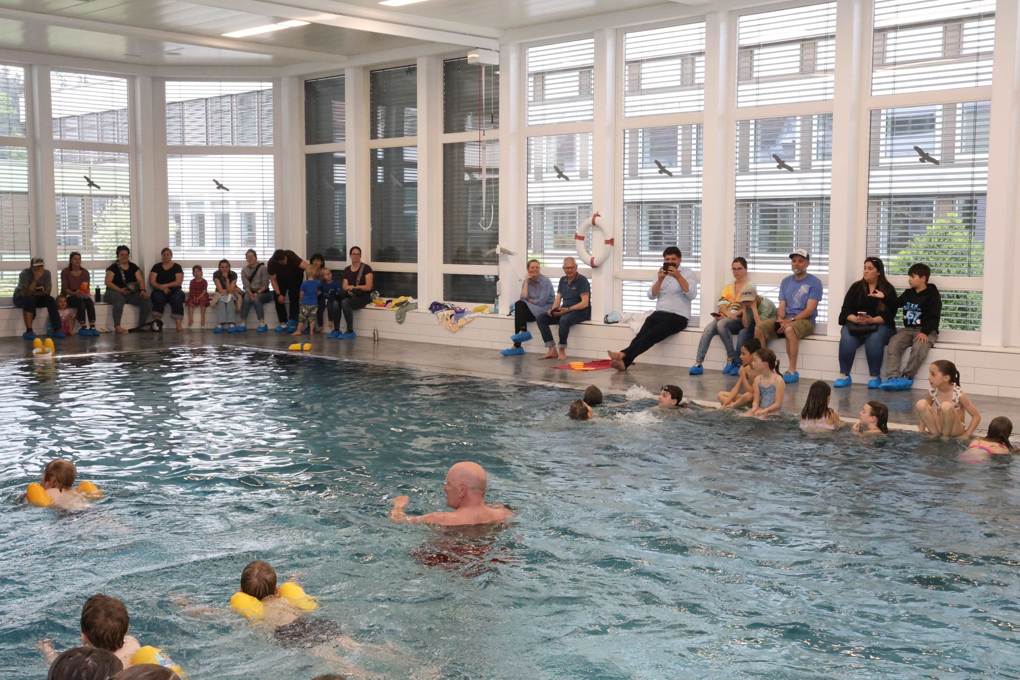 Eltern sahen ihren Sprößlingen beim Schwimmenlernen zu.
