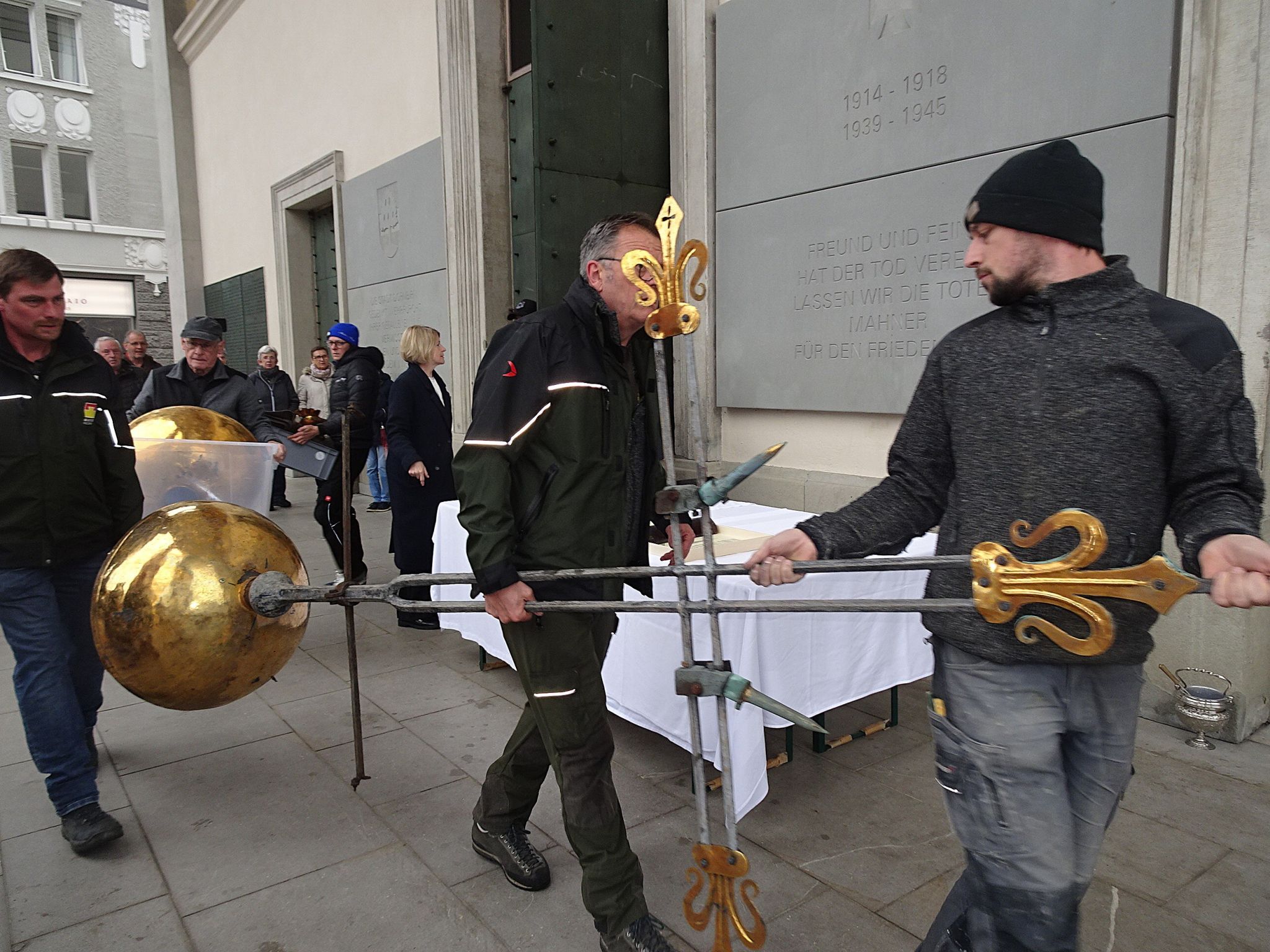 Die Arbeiter bringen die Kirchturmspitze zur Segnung. 