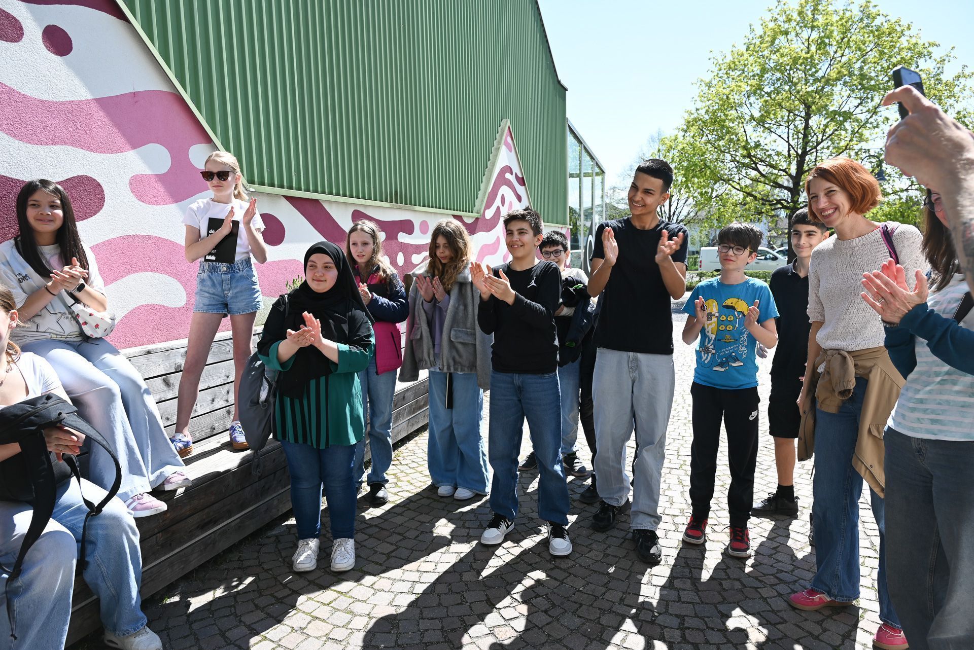 Voller Freude überreichen die Schüler ihre erste Geschichte beim dô.