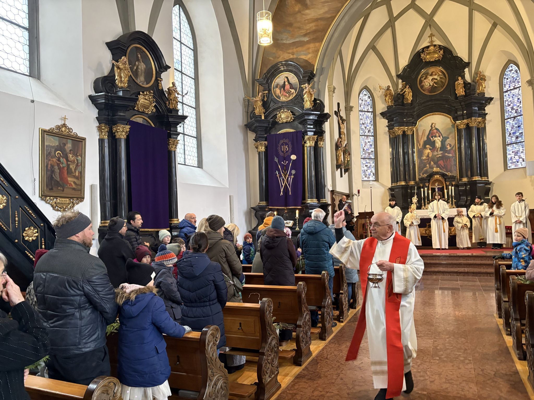 Pfarrer in Ruhe Roland Trentinaglia erbat Gottes Segen für die Anwesenden und deren Palmzweige.