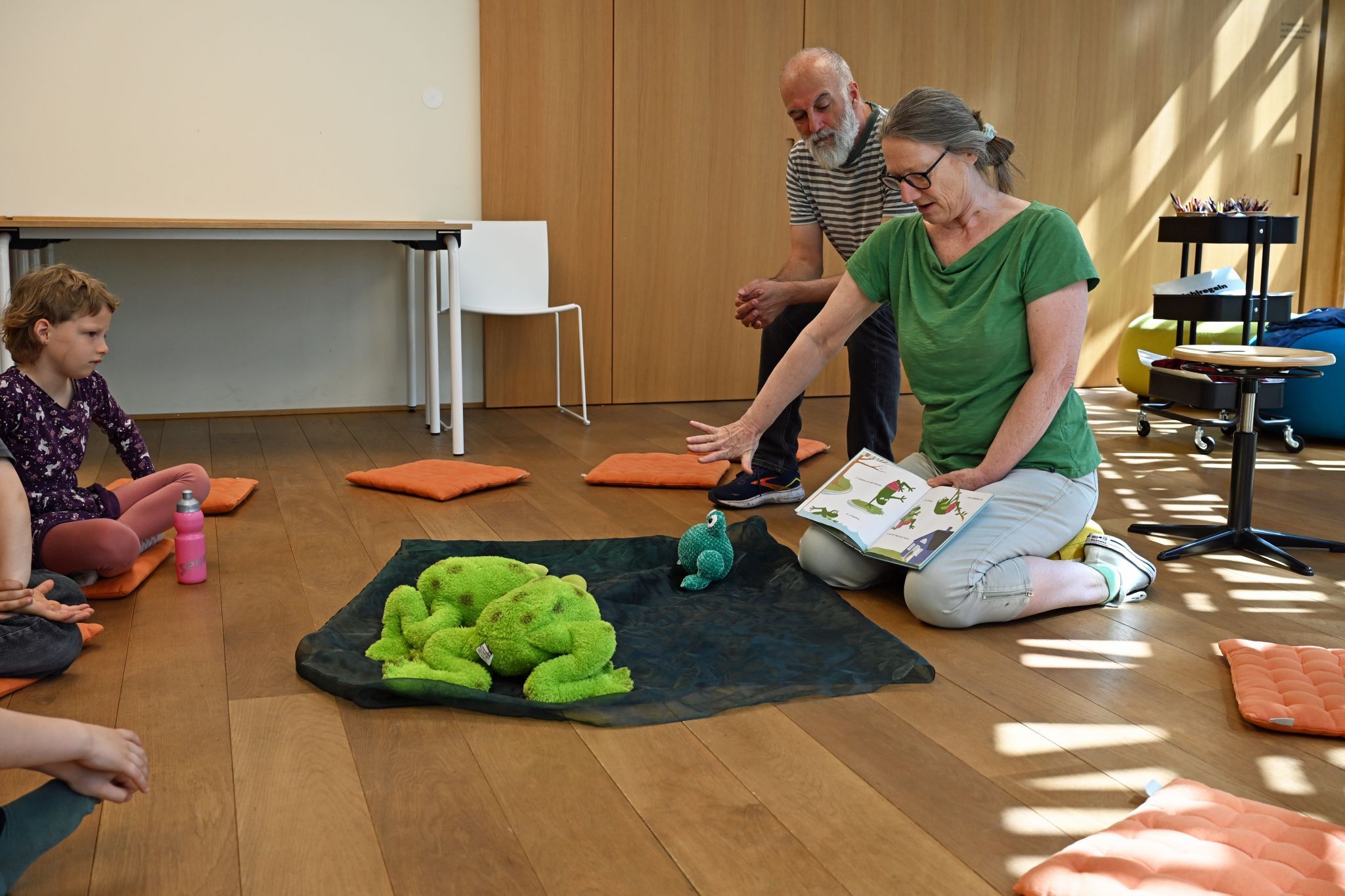 Edith las den Kindern die Geschichte „Hopp, hopp ins Bett!“ vor – darin geht es um einen Frosch, der nur hüpfen möchte.