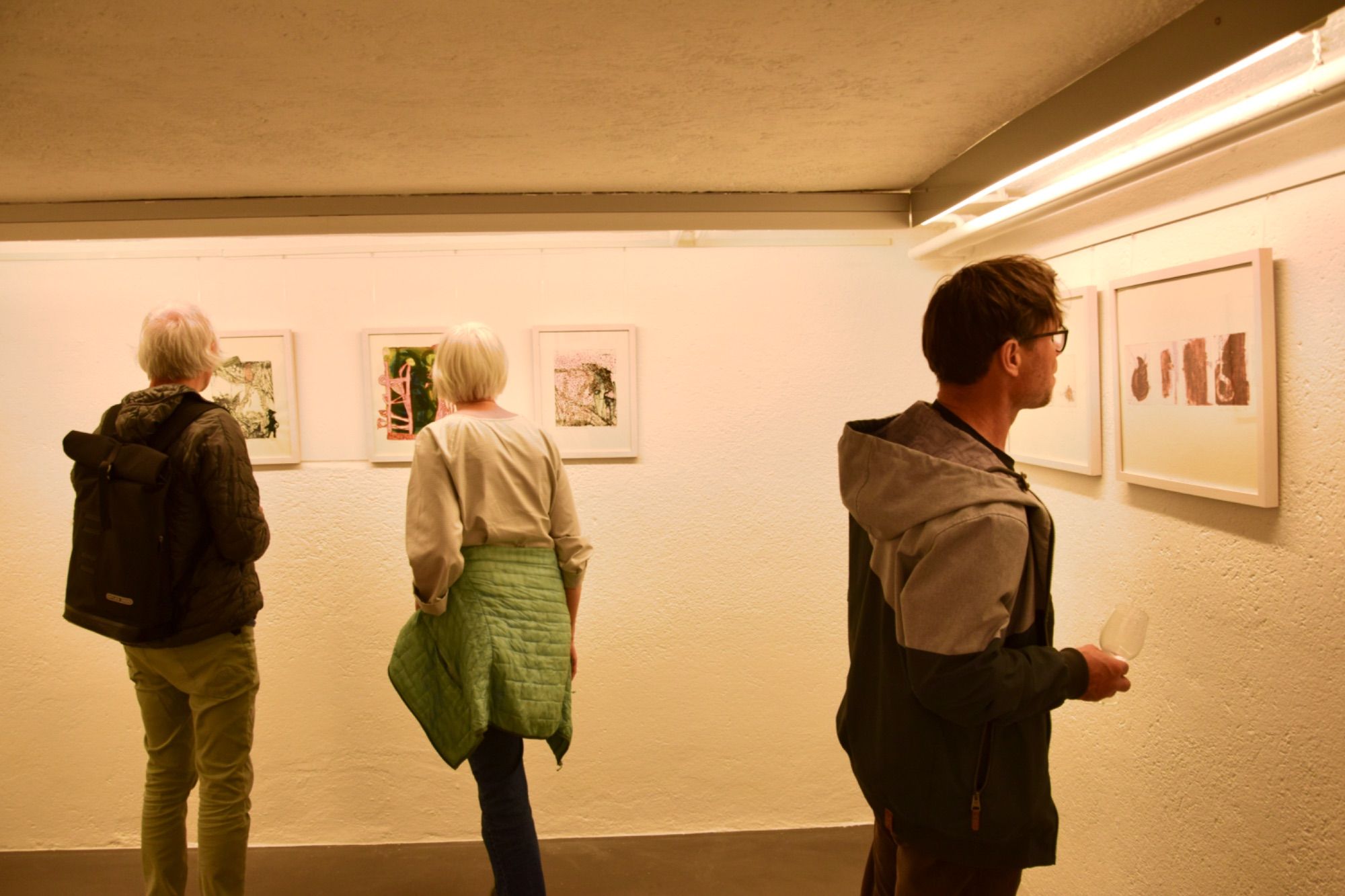 Vernissagebesucher und eine -besucherin in der Kellergalerie