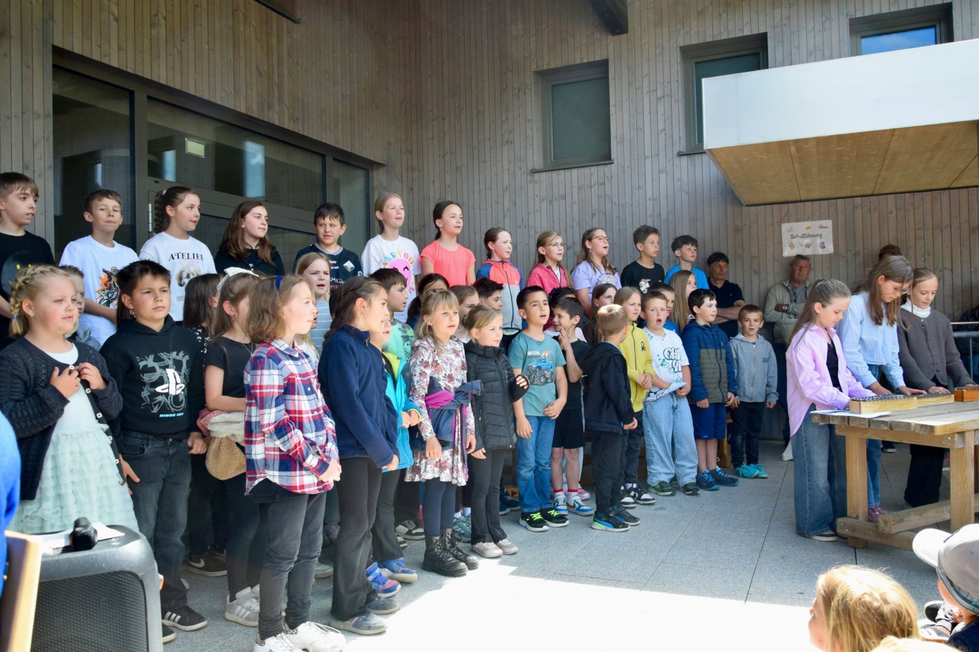 Kinder sangen und spielten auf Musikinstrumenten.