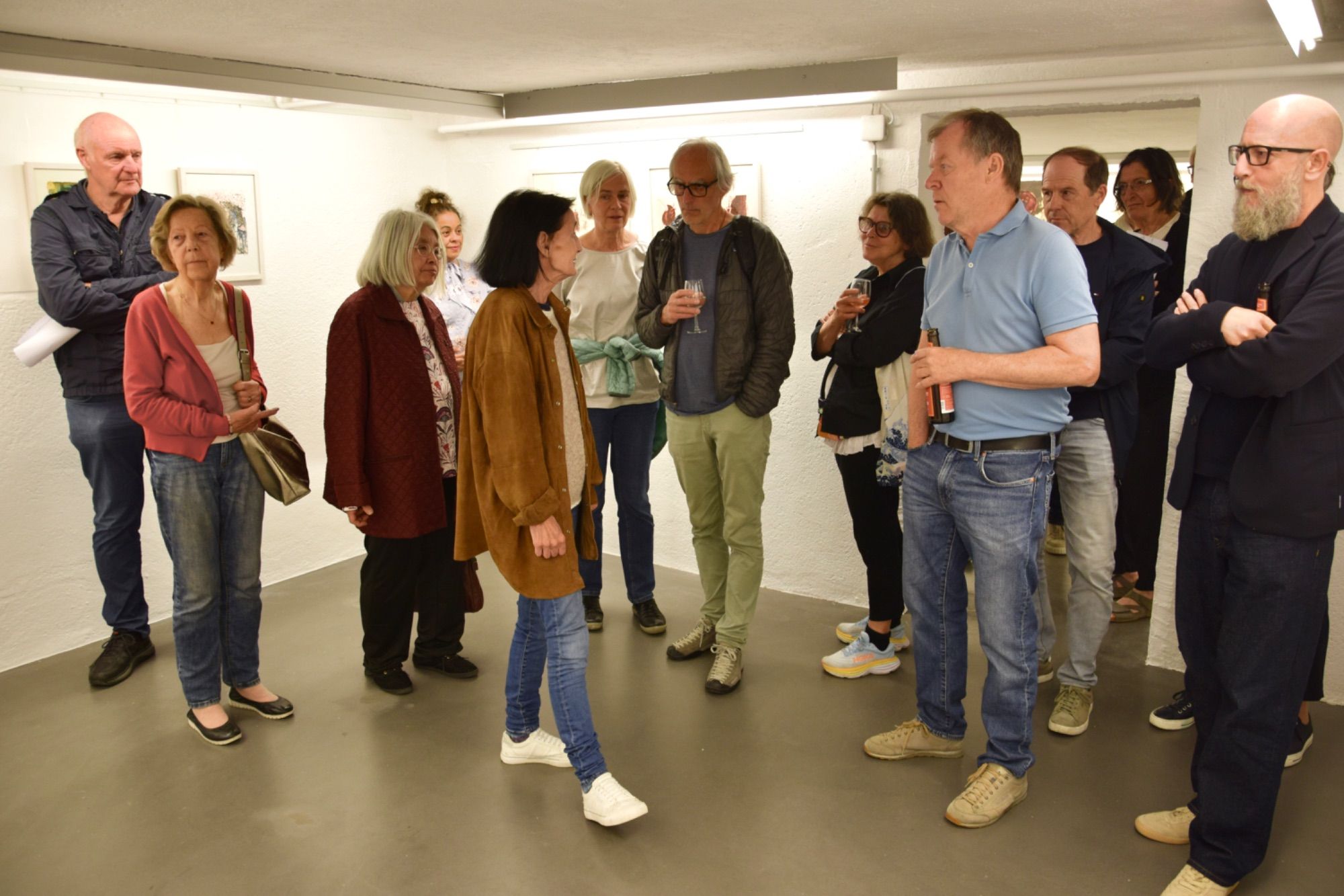 Eva Hörschläger (M.) führt durch ihre Ausstellung in der MAP Kellergalerie in Schruns.