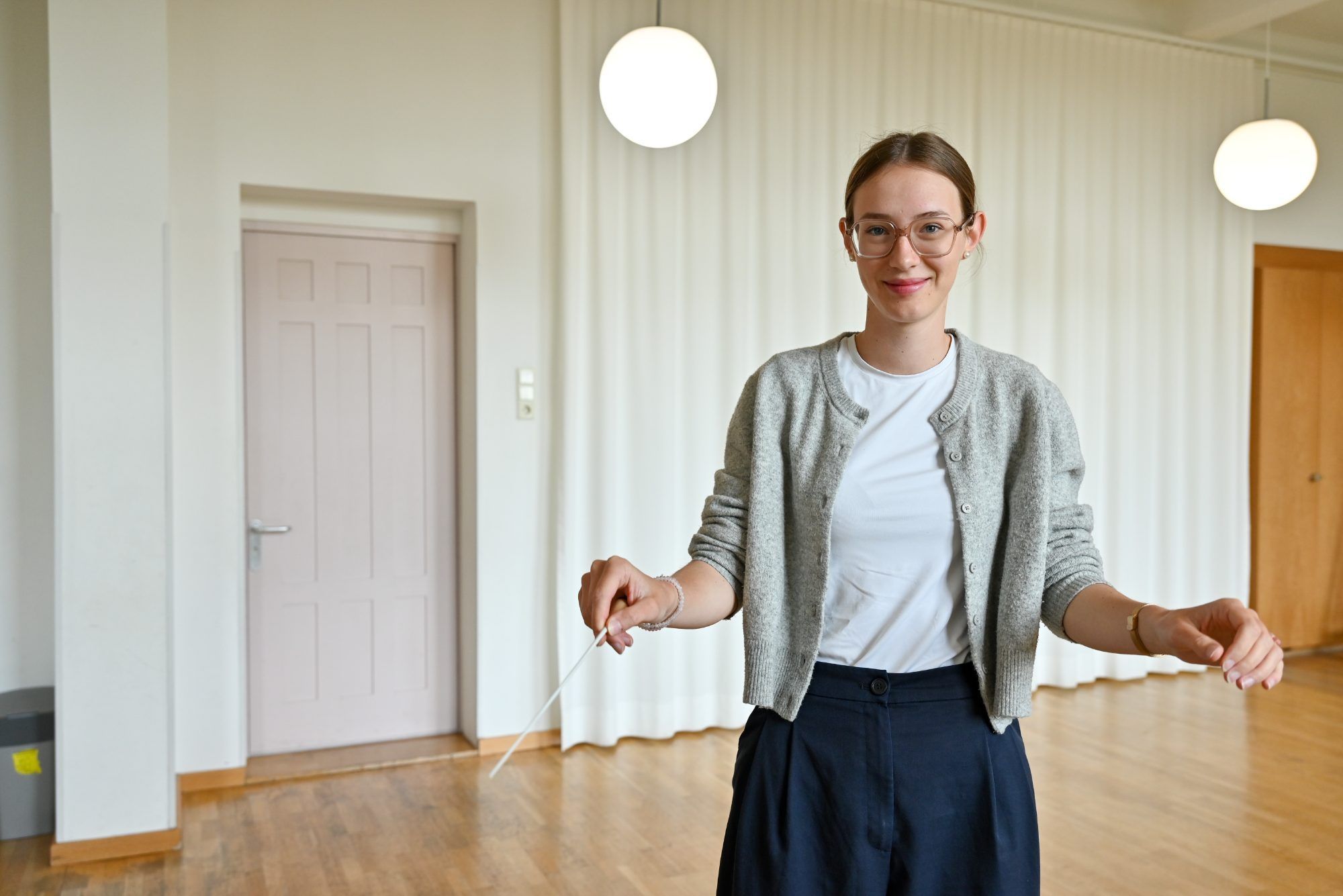 Wie mit einem Pinsel bewegt sie ihren Dirigierstab