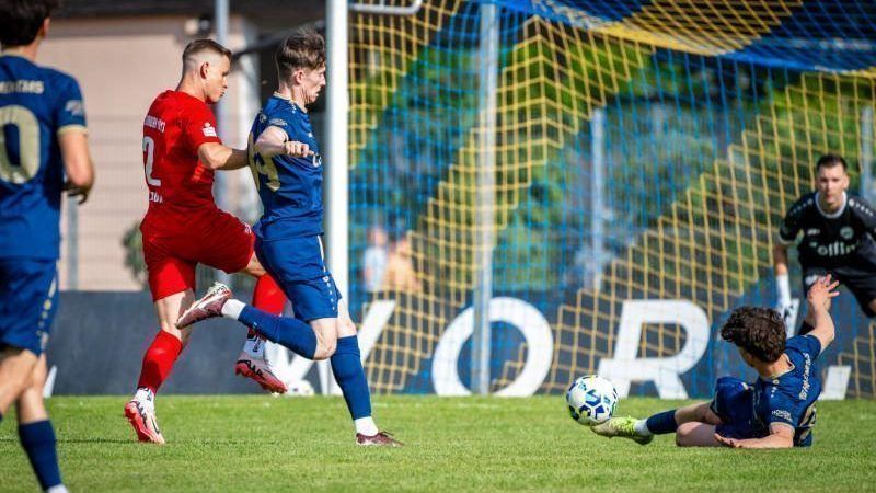 Hohenems Verteidiger Linus Winsauer (r. am Boden) spielt gegen seinen Exklub Alberschwende. VN-RHOMBERG