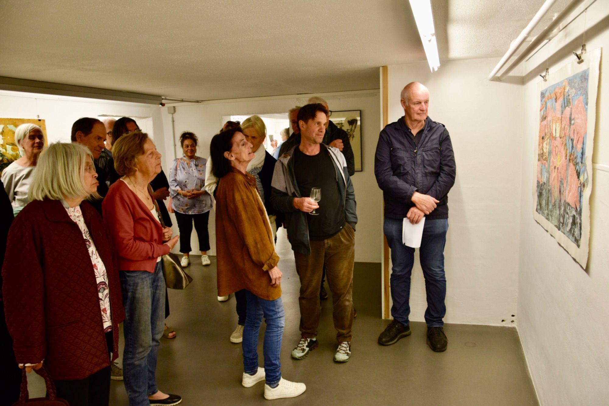 Eva Hörschläger (M.) führt durch ihre Ausstellung in der MAP Kellergalerie in Schruns.