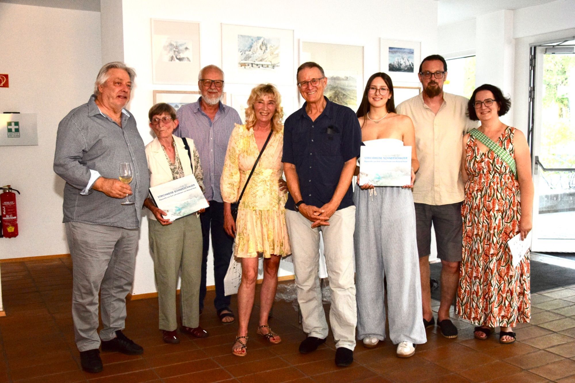 Künstler Roland Haas (5. v. l.), Kulturkritiker Karlheinz Pichler (l.), Künstler Hubert Lampert (3. v. l.), Kulturjournalistin Ingrid Bertel (4. v. l.), Laura Agostinelli (Lektorat, 3. v. r.) mit Besuchern der Buchvorstellung im Bildungshaus