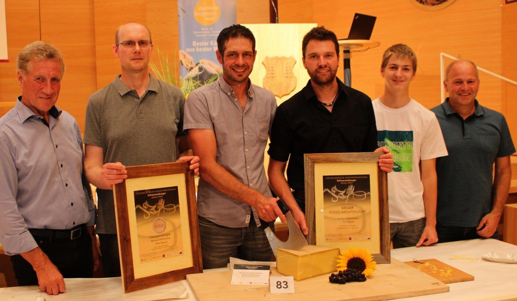 Für den früheren Agrarlandesrat Erich Schwärzler (li.) ist es in Schwarzenberg liebgewordene Routine, dem Team der Sennerei Riefensberg - im Bild Stefan Eich, Daniel Fink, Simon Kretz, Benjamin und Raimund Fink - zu gratulieren. Zuletzt 2023 und 2024 zum Konsumentensieg, 2021 und 2014 zum Senner des Jahres und jetzt auch - nach 2024 - zum zweiten Kasermandl.