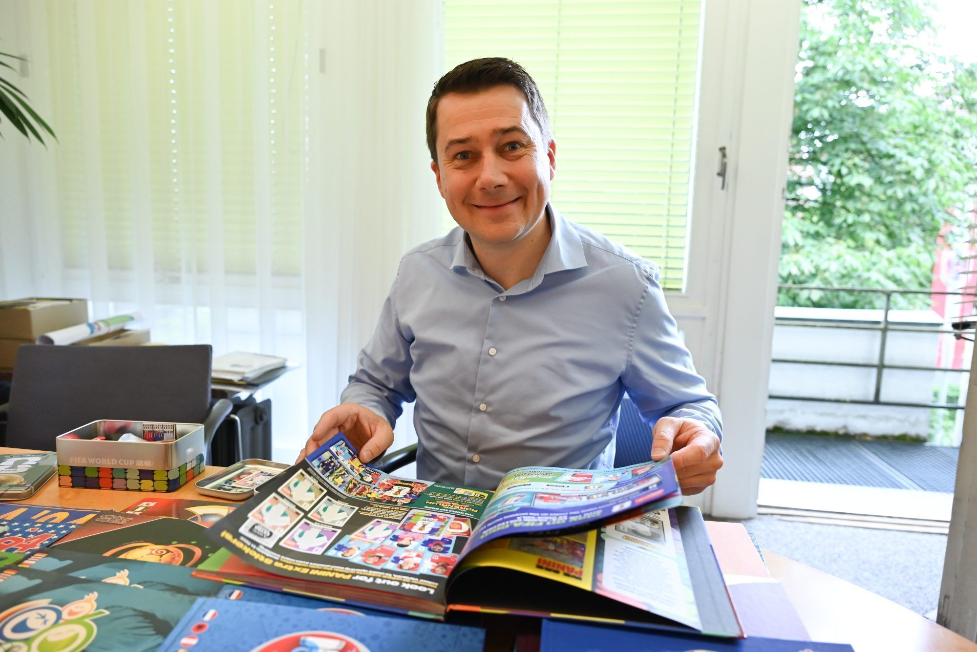 Gerne blättert er durch die Fußballhefte und betrachtet seine Sammlung.