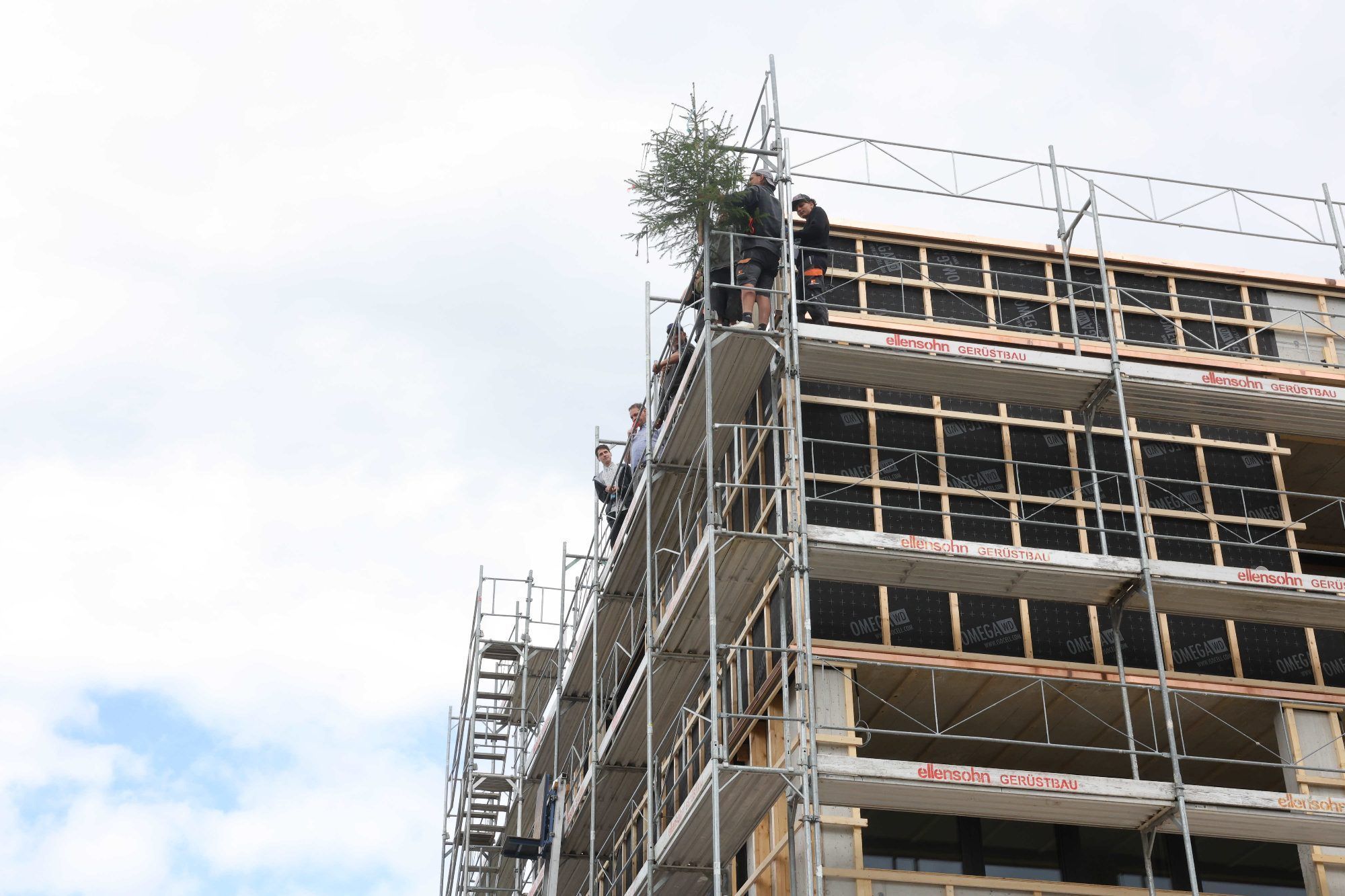 Auf einem der Gebäude wurde der Firstbaum befestigt.