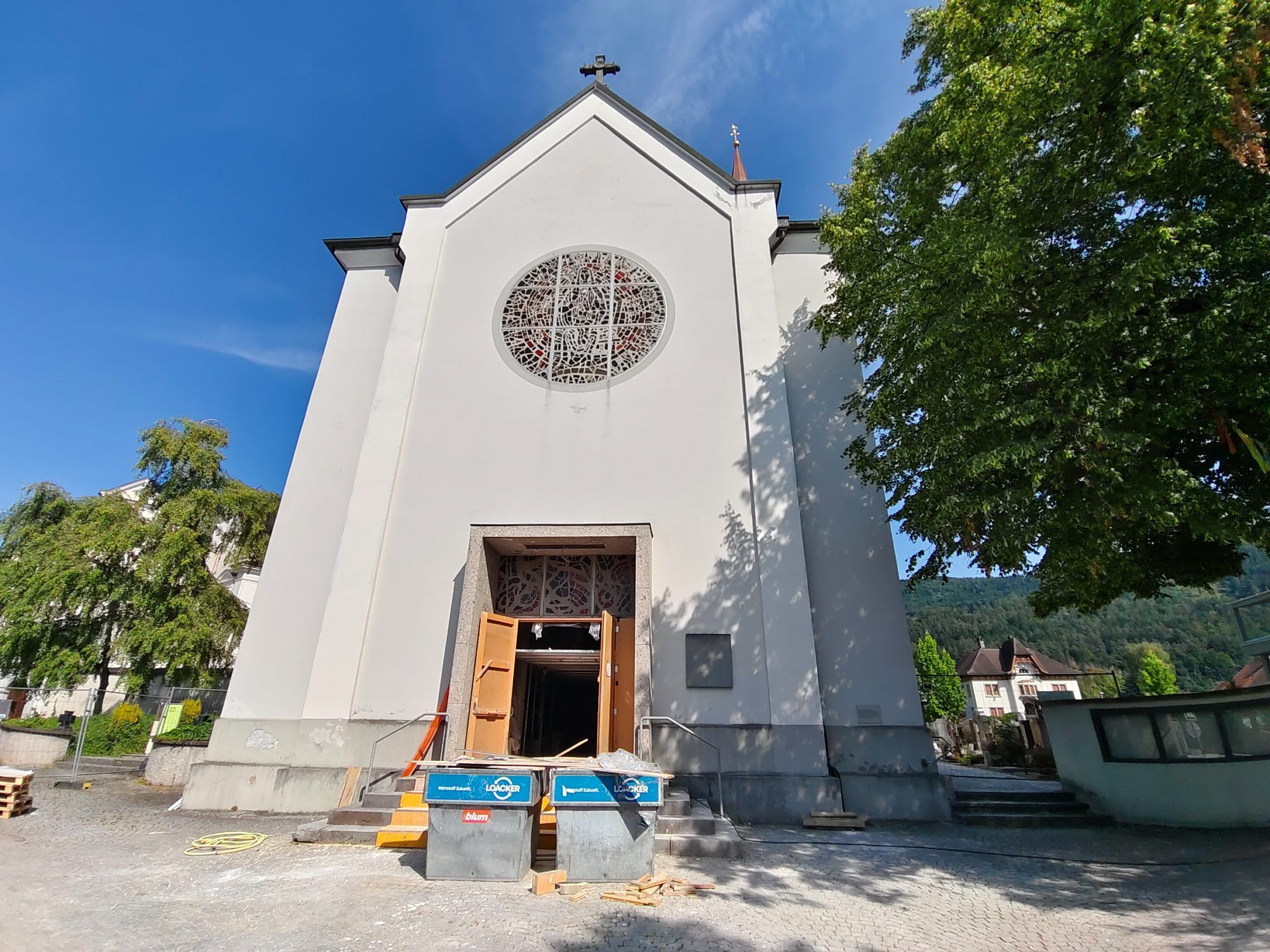 Container vor der Pfarrkirche sind ein unzweideutiges Zeichen, dass die Bautätigkeit noch im Gang ist.