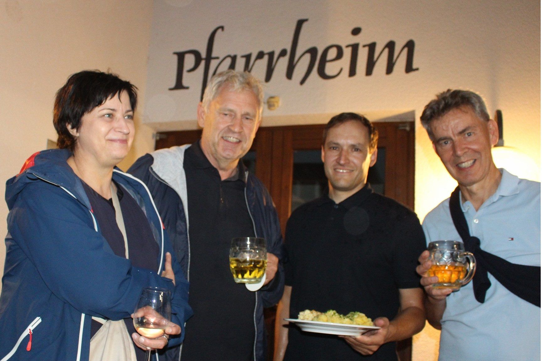 In den Pfarrheim-Eingang „flüchteten“ Bürgermeister Klaus Sohm, „Käsklatsch-Erfinder“ Lothar Eiler und seine Partnerin Helene sowie Hannes Burtscher (re.), um vor dem Regenschauer Schutz zu finden.