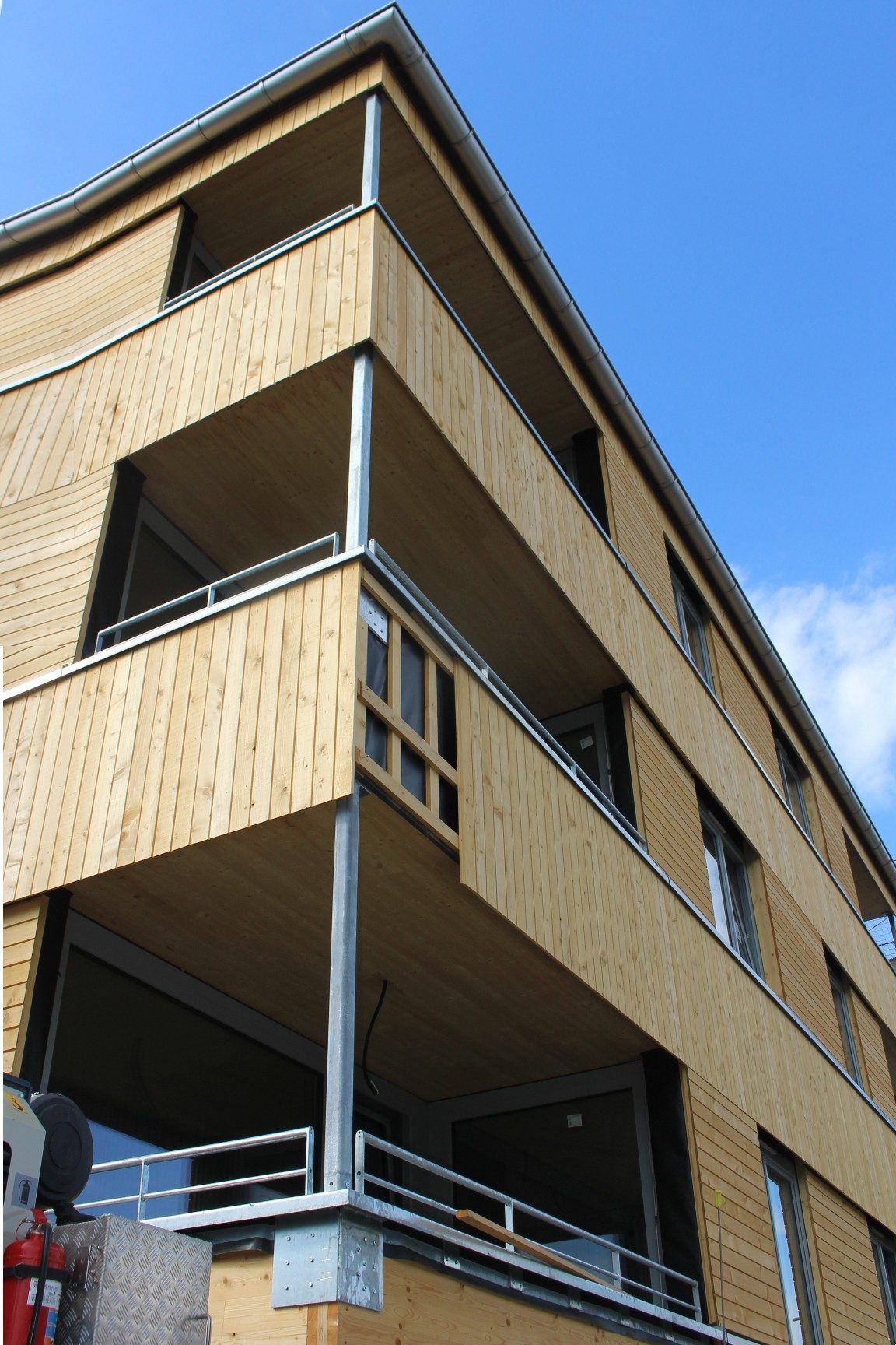 Beim ersten Haus sind die Arbeiten soweit fortgeschritten, dass das Baugerüst entfernt werden konnte und erkennbar ist, wie die Holzfassade des Objekts im Endzustand aussehen wird.