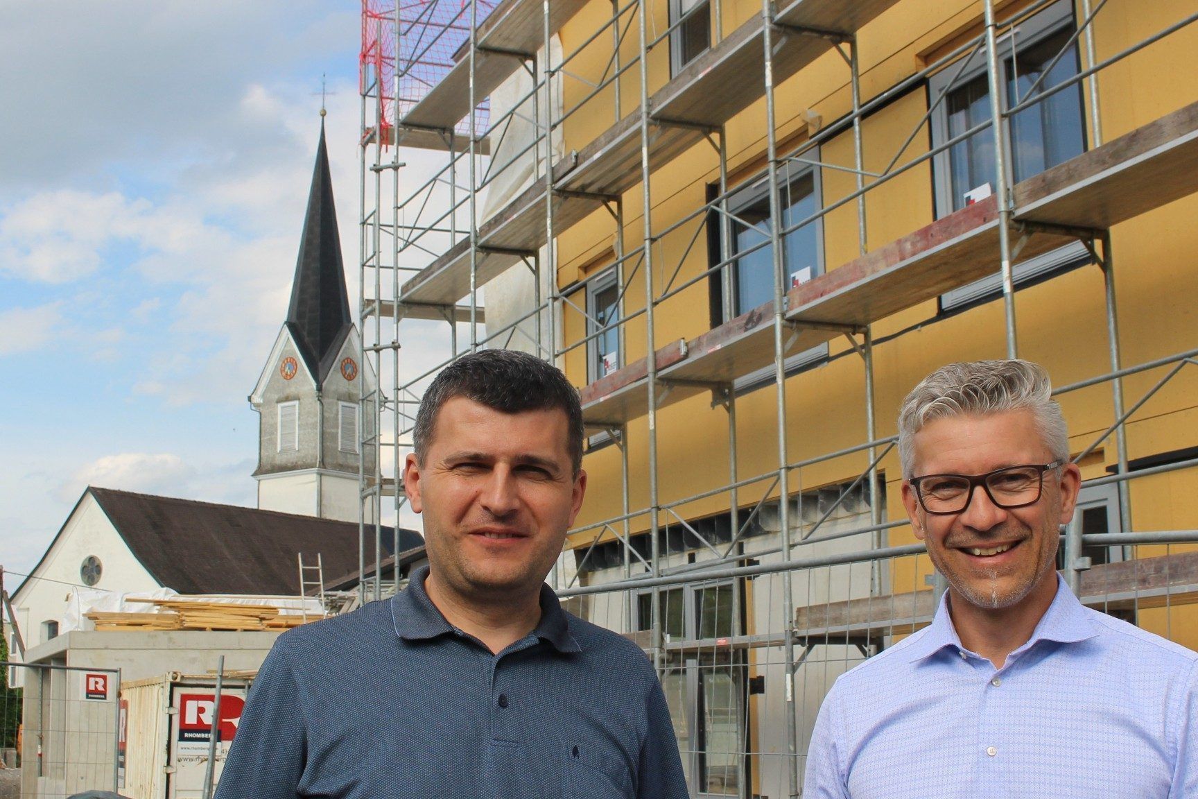 Im Hohenweiler Zentrum entsteht derzeit in Rufweite zur Pfarrkiche eine Wohnanlage mit 30 Einheiten. Wohnbauselbsthilfe-Geschäftsführer Thomas Schöpf und Projektleiter Mitar Simikic luden zum Lokalaugenschein auf die Großbaustelle. PETER STRAUSS
