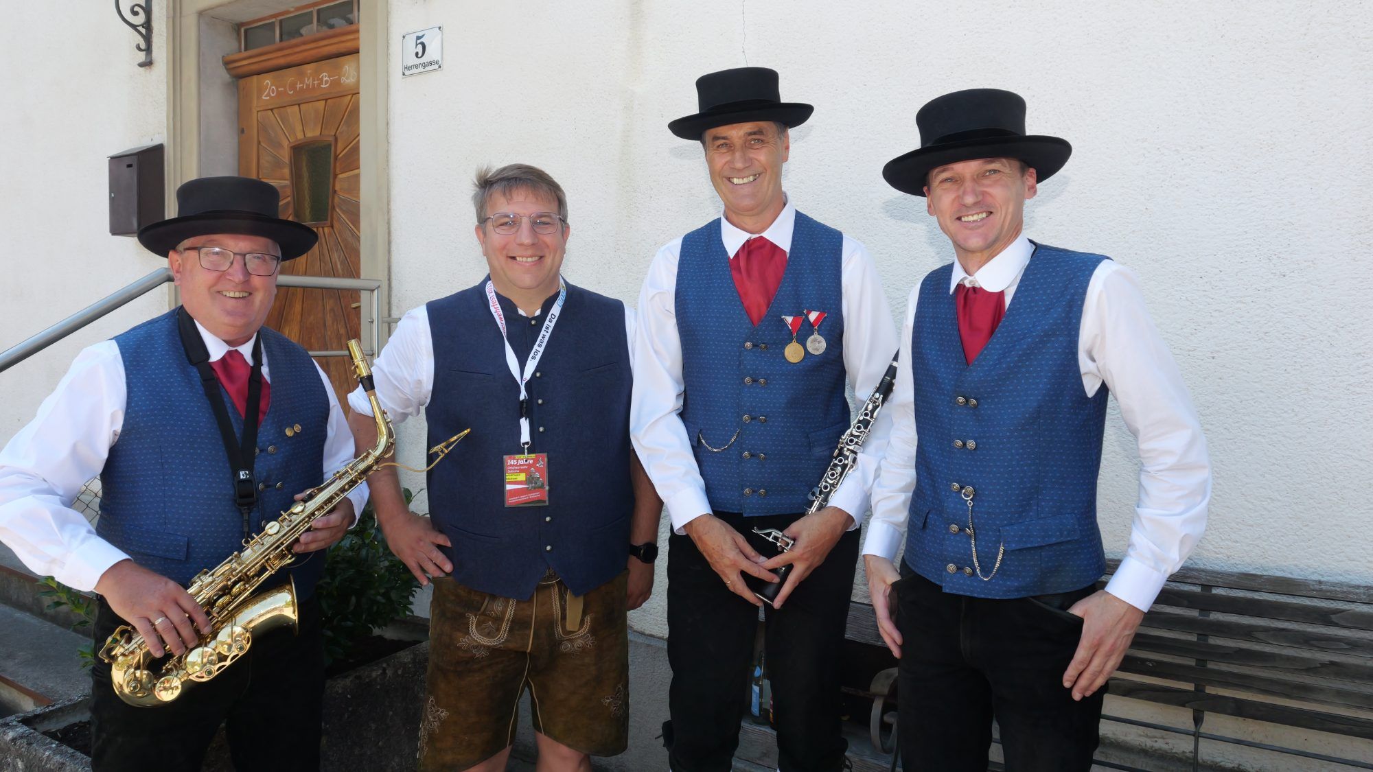 Gebhard Berchtel, Johannes Berchtel und Oswald Amann von der Gemeindemusik Satteins mit Festführer Michael Koschat.