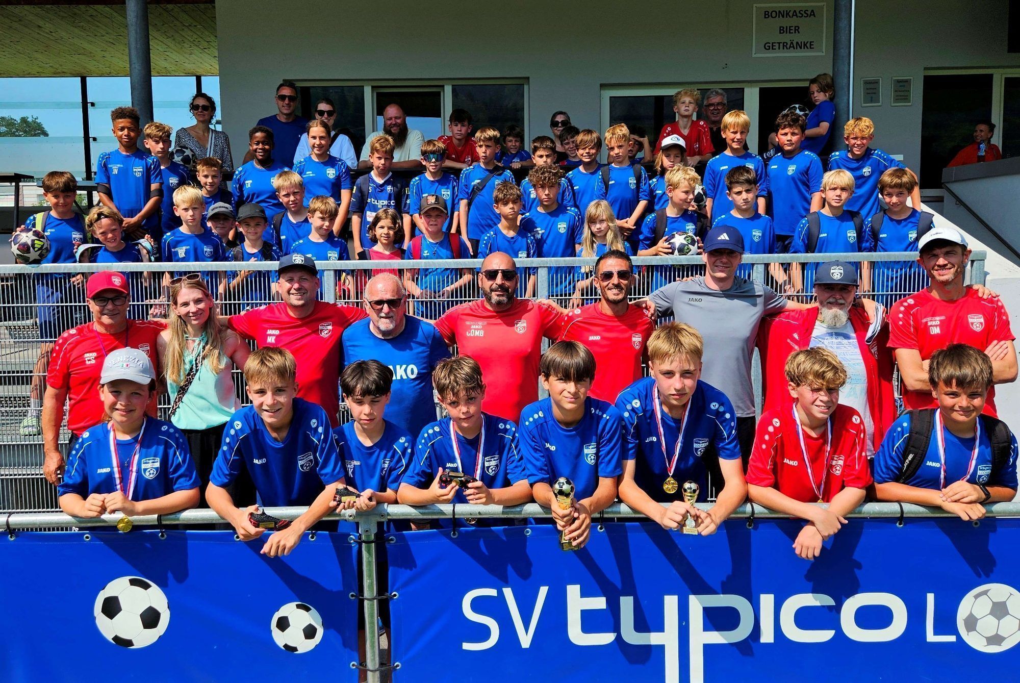 Das große Abschlussfoto des „Leiblachtaler-Raiffeisen-Fußball-Nachwuchs-Camp 2026“ des SV typico Lochau nach der Siegerehrung. Über fünfzig Buben und Mädchen von sieben bis 13 Jahren waren im Stadion Hoferfeld in diesem Jahr mit Begeisterung dabei.