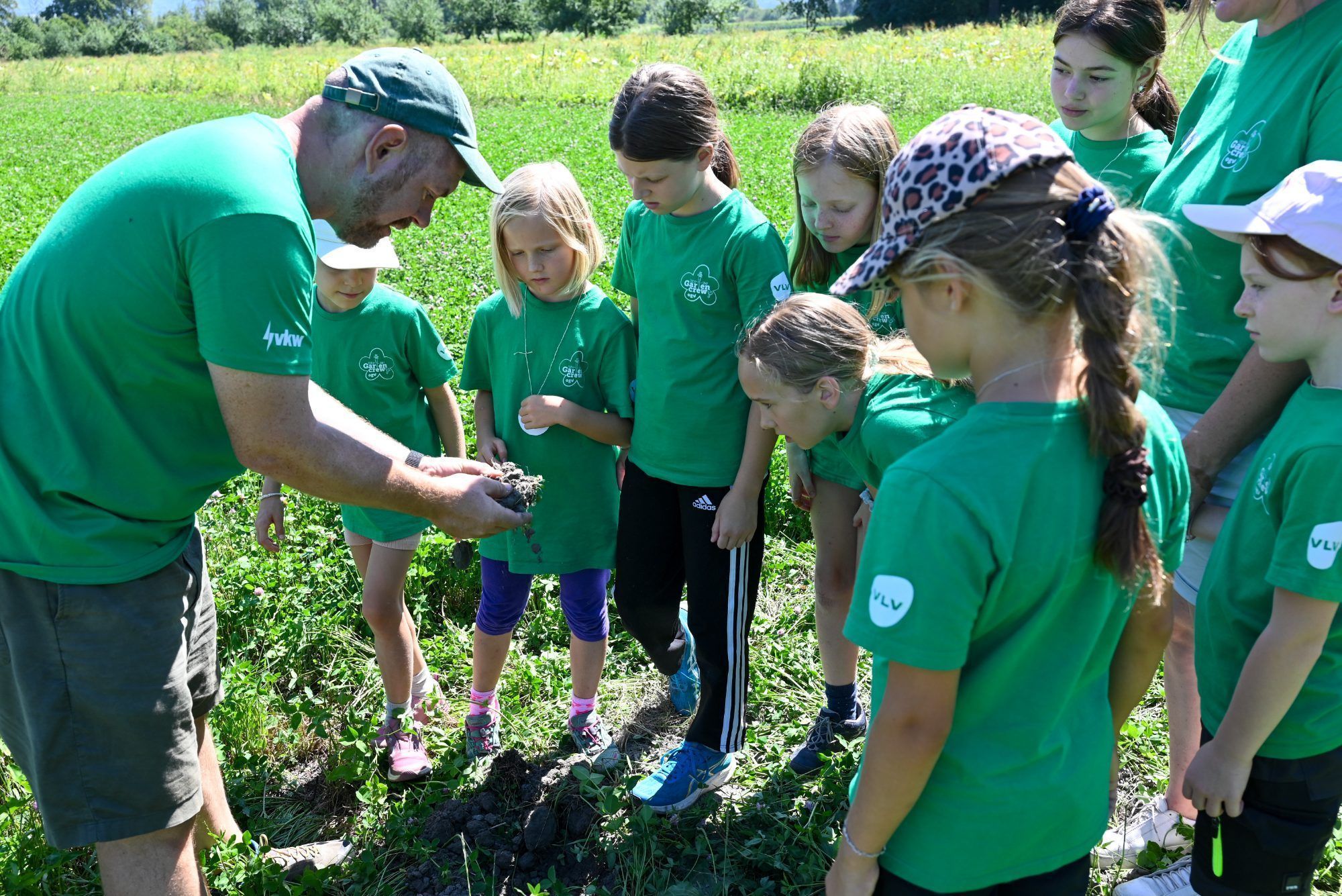 Landwirt Simon Vetter zeigten den Kindern die sandige Erde, die beim Heidensand zu finden ist.