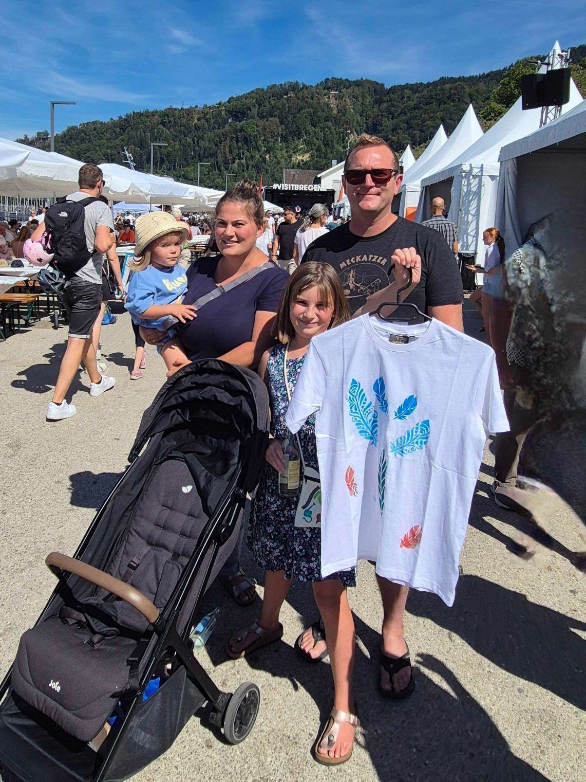 Anna-Lena aus dem Allgäu zeigt stolz ihr T-Shirt, selbstgestaltet beim Kinderprogramm
