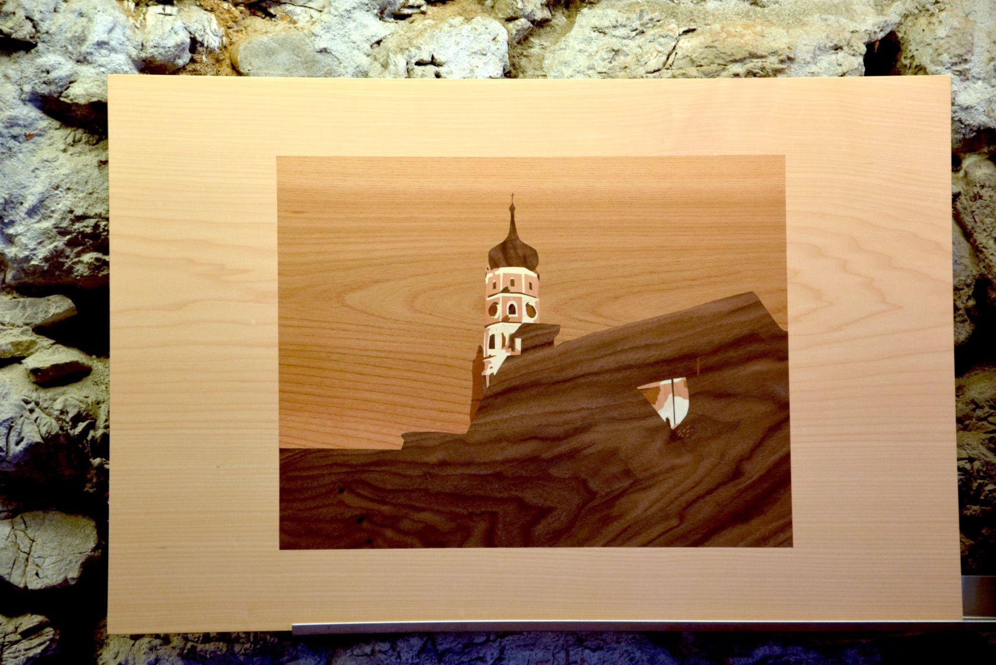 Die St. Laurentiuskirche, hoch über den Dächern von Bludenz, dargestellt in einer Arbeit des Intarsienkünstlers Markus Khüny - ausgestellt in einem seiner früheren offenen Sommerateliers in Lorüns. Foto: Gerhard Scopoli