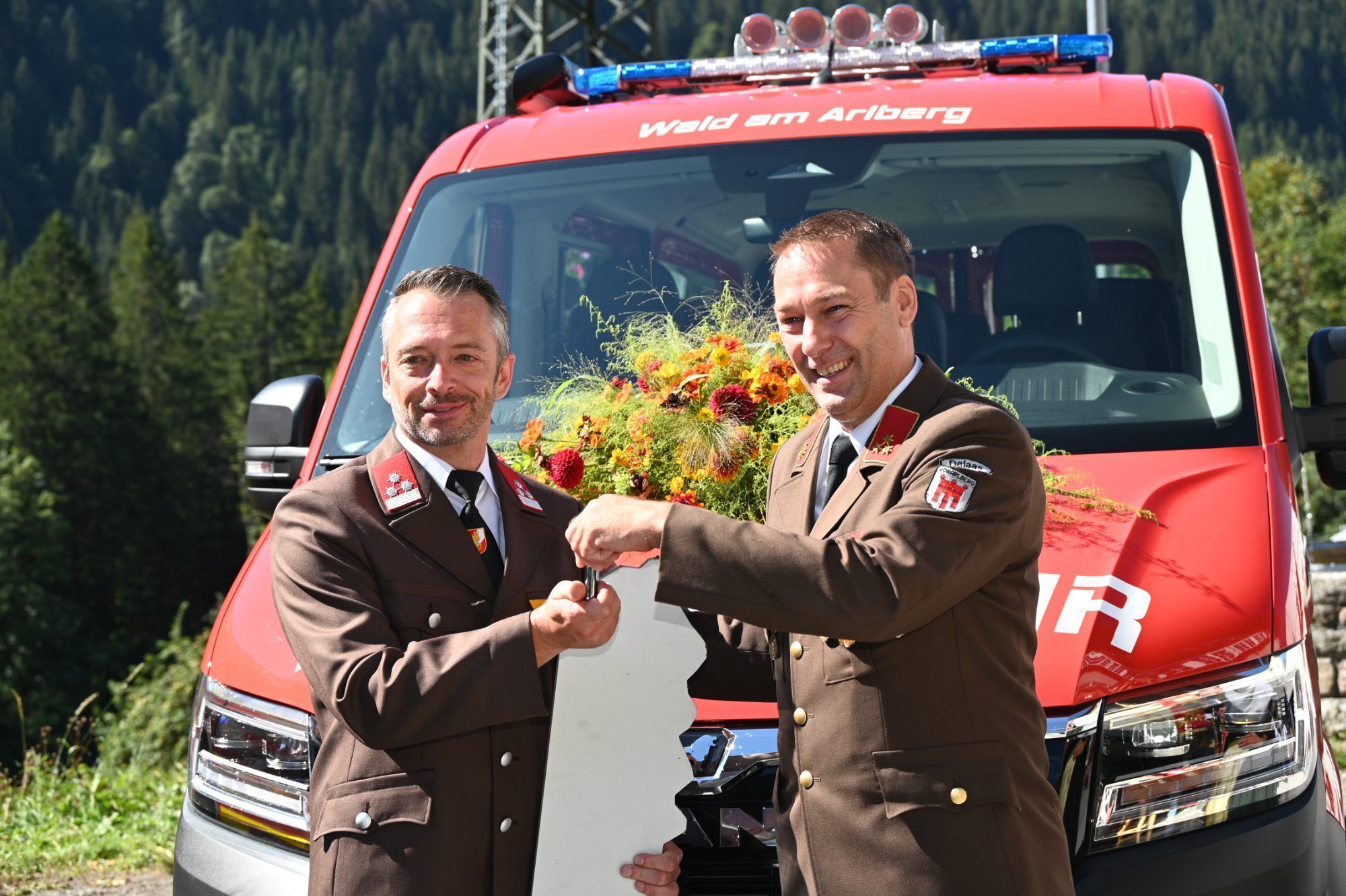 Bürgermeister Martin Burtscher übergibt den Schlüssel an Fahrzeugwart Alexander Schöpf.