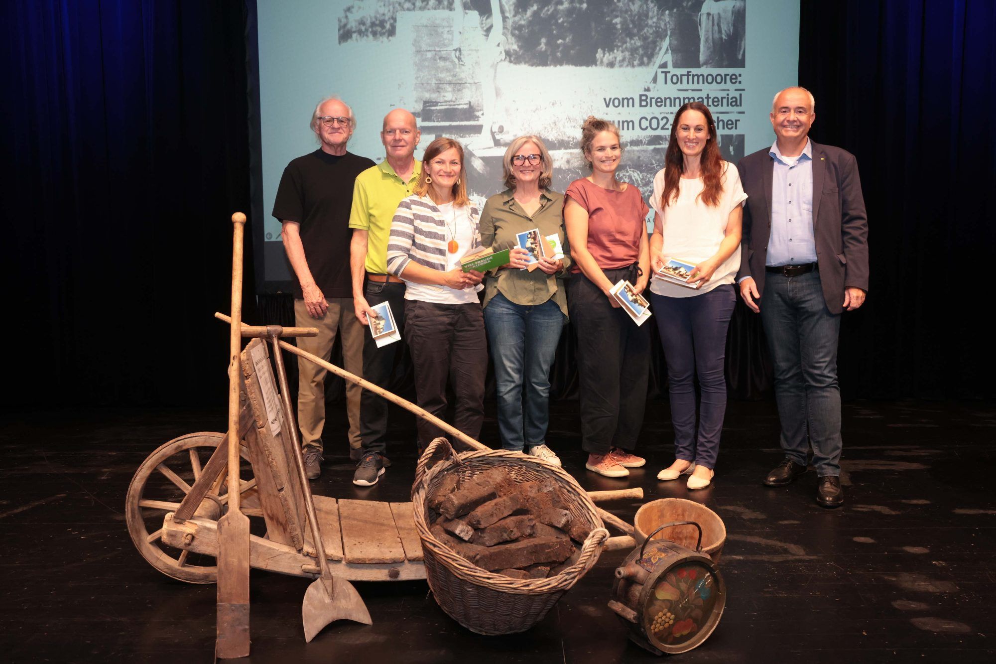 Wolfgang Berchtold, Reinhard Häusle, Romana Steinparzer-Kirisits, Christiane Machold, Sophie Baumschlager, Petra Häfele und der fürs Schlusswort zuständige Bgm. Manfred Böhmwalder mit Gerätschaften zum Schollenstechen. Foto: Arno Meusburger
