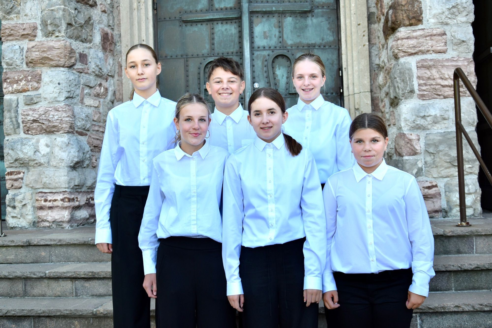 Vor den Stufen der Heilig-Kreuz-Kirche in Bludenz, die sechs Neuzugänge bei der Stadtmusik Bludenz: vorne Mia Egger, Mathilde Walch, Maya Meznar, hinten Paulina Fitsch, Fabio Juriatti und Lisa Neyer.