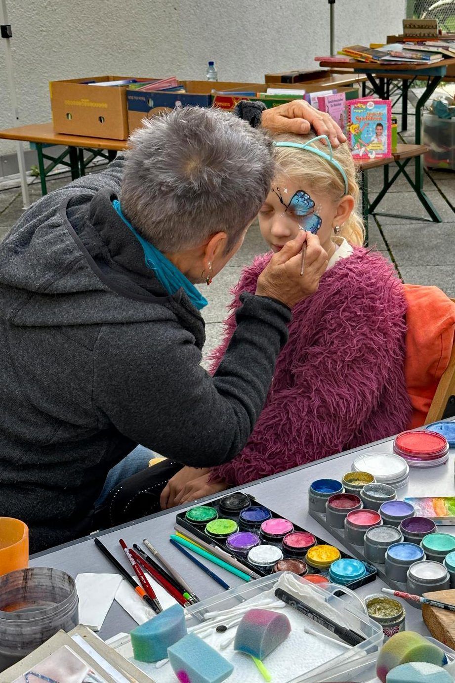 Die Kinder werden kunstvoll geschminkt.
