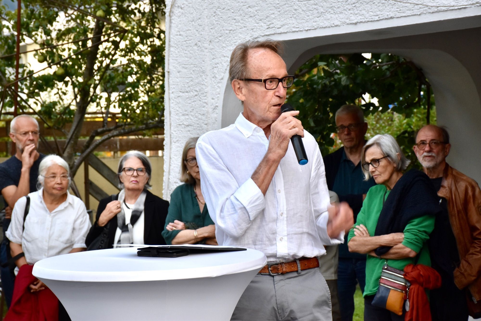 Moderator Bruno Winkler mit Vernissagebesuchern im Garten der Galerie.