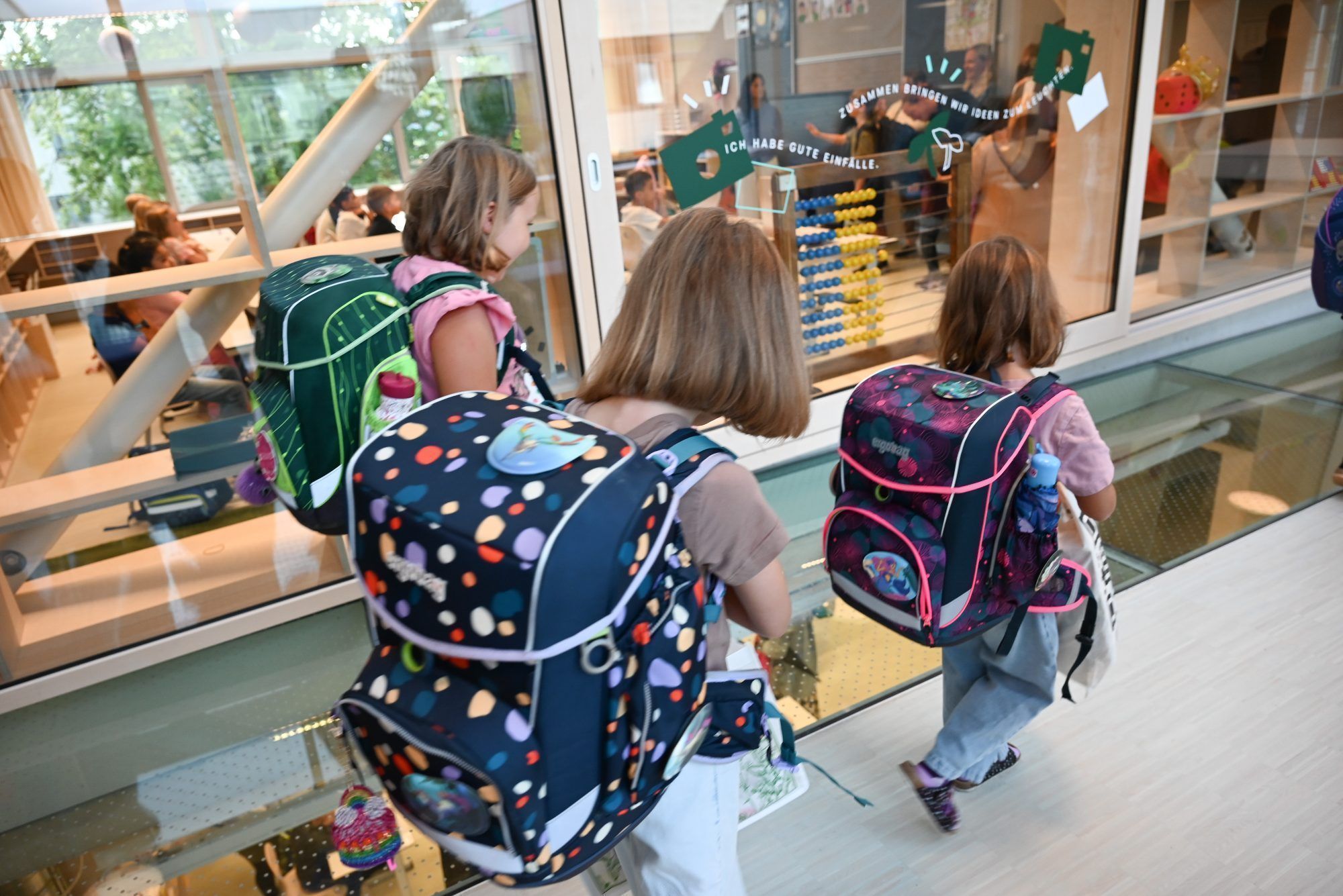 Aufgeregt gehen die Kinder über einen verglasten Boden.