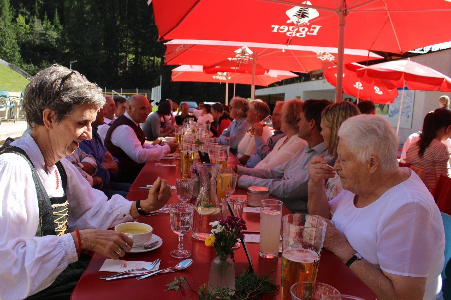 Beim Mittagessen und anschließendem gemütlichen Beisammensein klang die Amtseinführung von Pfarrer Friedel im Berghaus-Gastgarten aus – unter roten Sonnenschirmen, die an seine frühere Wirkungsstätte Egg erinnerten . . .