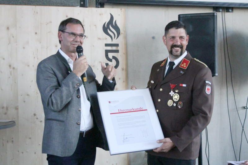 Markus Wallner überreicht Mathias Walser die Ehrenurkunde vom Land Vorarlberg.