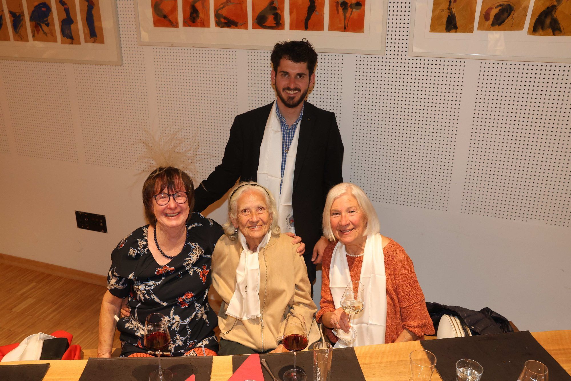Kaplan Jakob Geier mit Waltraud Mayer, Renate Unterfurtner und Barbara Wagner sowie einer Tischdekoration als Kopfschmuck.