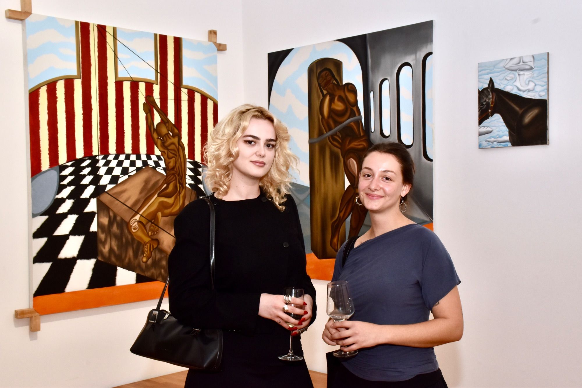 Amalia Biltz und Laura Engstler vor Werken Tyrone Egbowons im Kunstraum Remise in Bludenz.