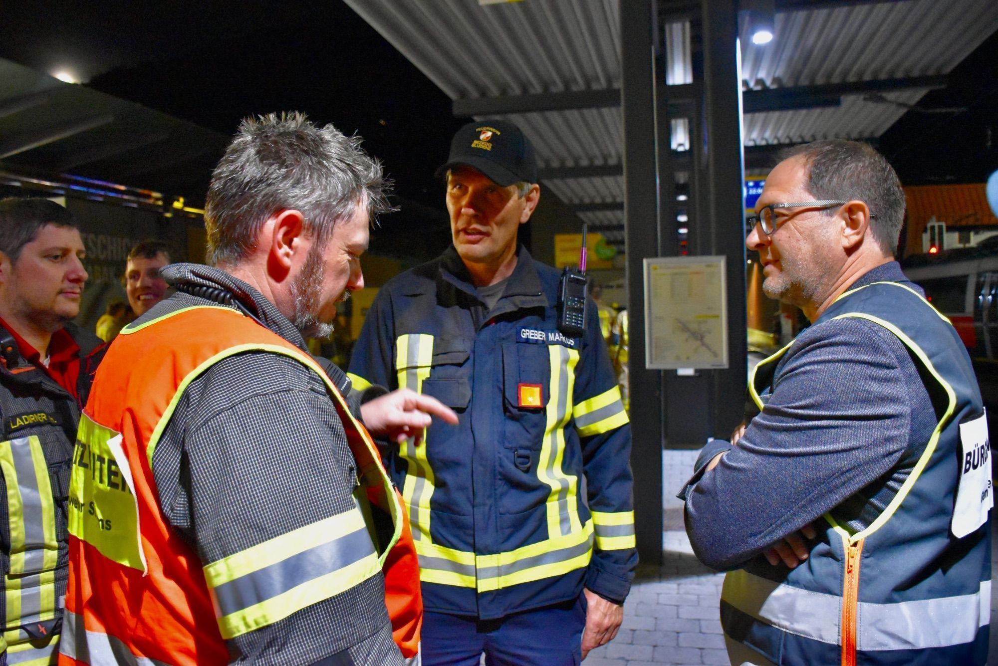 Einsatzleiter Feuerwehrkommandant Martin Jenny, Abschnittsfeuerwehrkommandant Markus Greber und der Schrunser Bürgermeister Jürgen Haller im Gespräch, hier am Bahnhof Schruns.