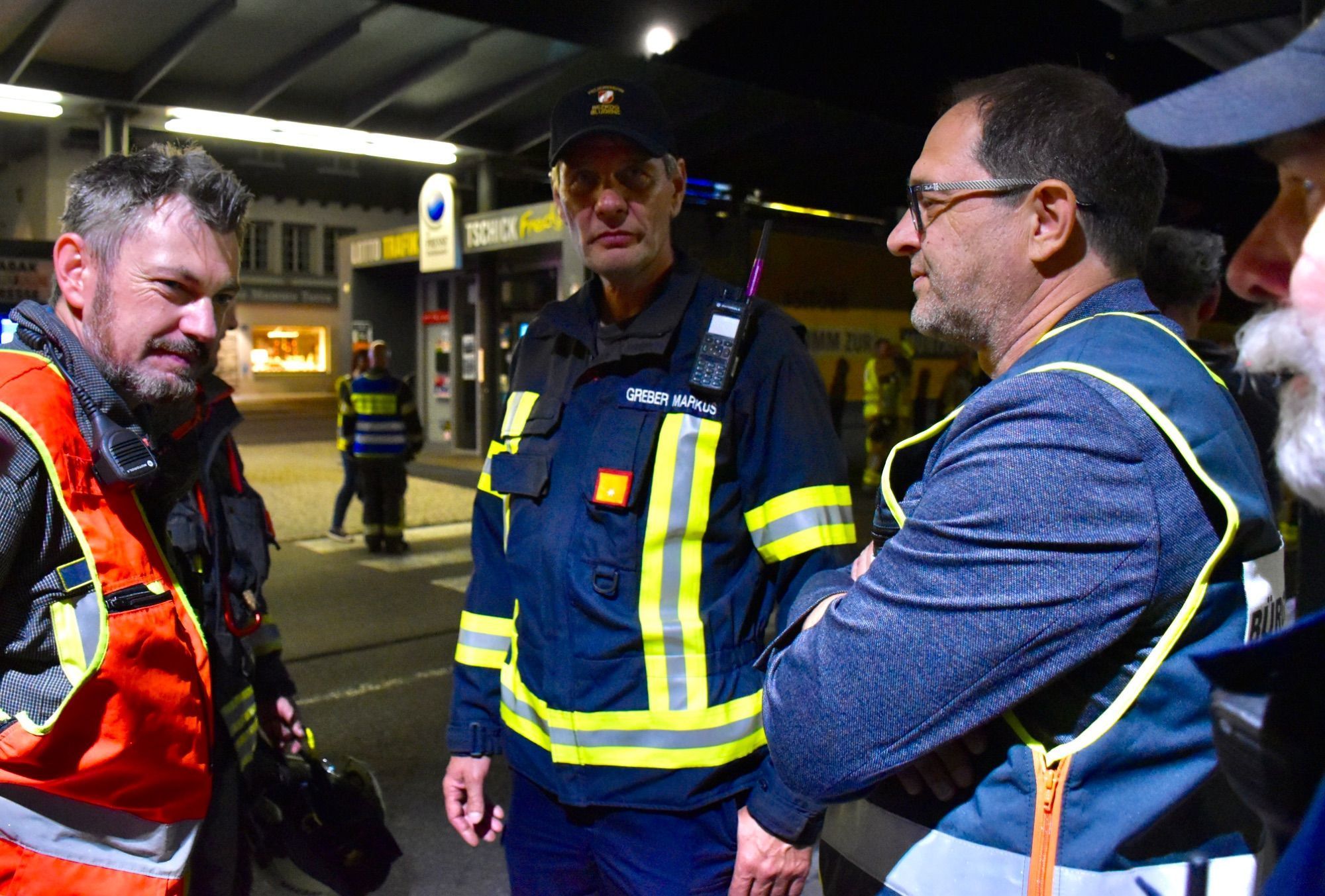 Feuerwehrkommandant Martin Jenny, Abschnittsfeuerwehrkommandant Markus Greber und der Schrunser Bürgermeister Jürgen Haller im Gespräch, hier am Bahnhof Schruns.